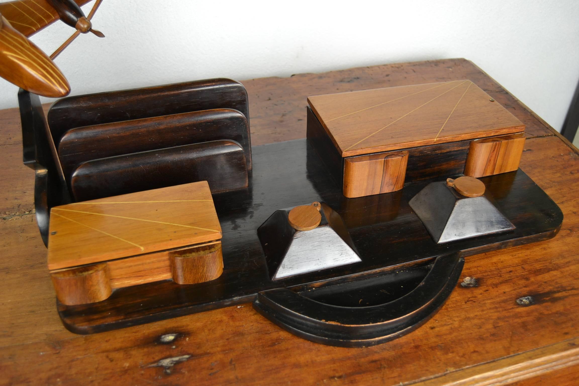 Stylish Art Deco wooden desk set with airplane on top.
Handmade big desk set with letter holder, two inkwells, two storage boxes and plane on top which can be put in different positions.
Nice details and use of inlaid wood.
Awesome desk accessory,