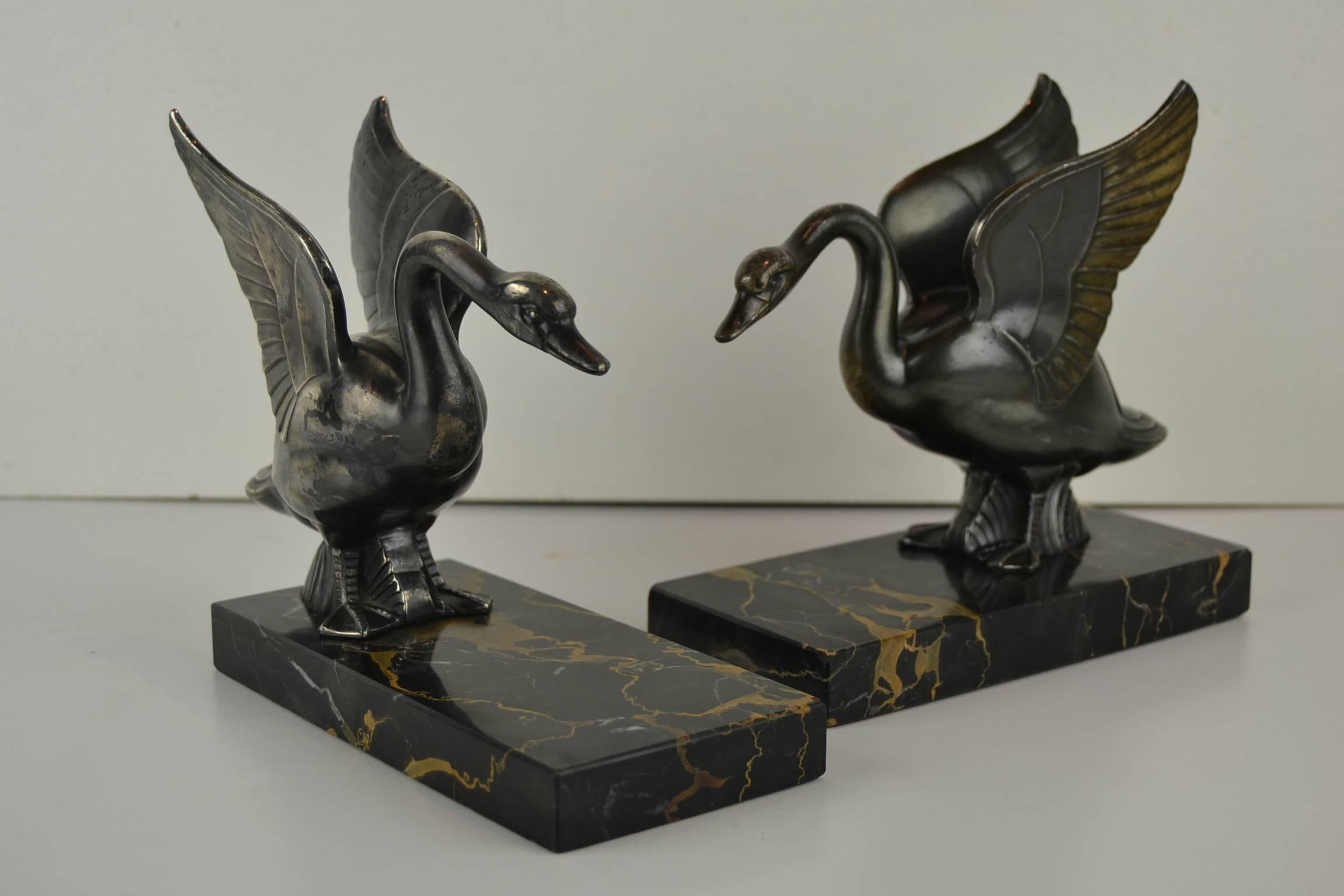Impressive Pair of Large Art Deco Bookends with Swans .
These Animal Bookends were Made and Signed by Perrina Paris, France, circa 1930.
Bronzed Patina Painted Metal Swans Sculptures mounted over black and brown Marble Bases. 
Due age and use slight