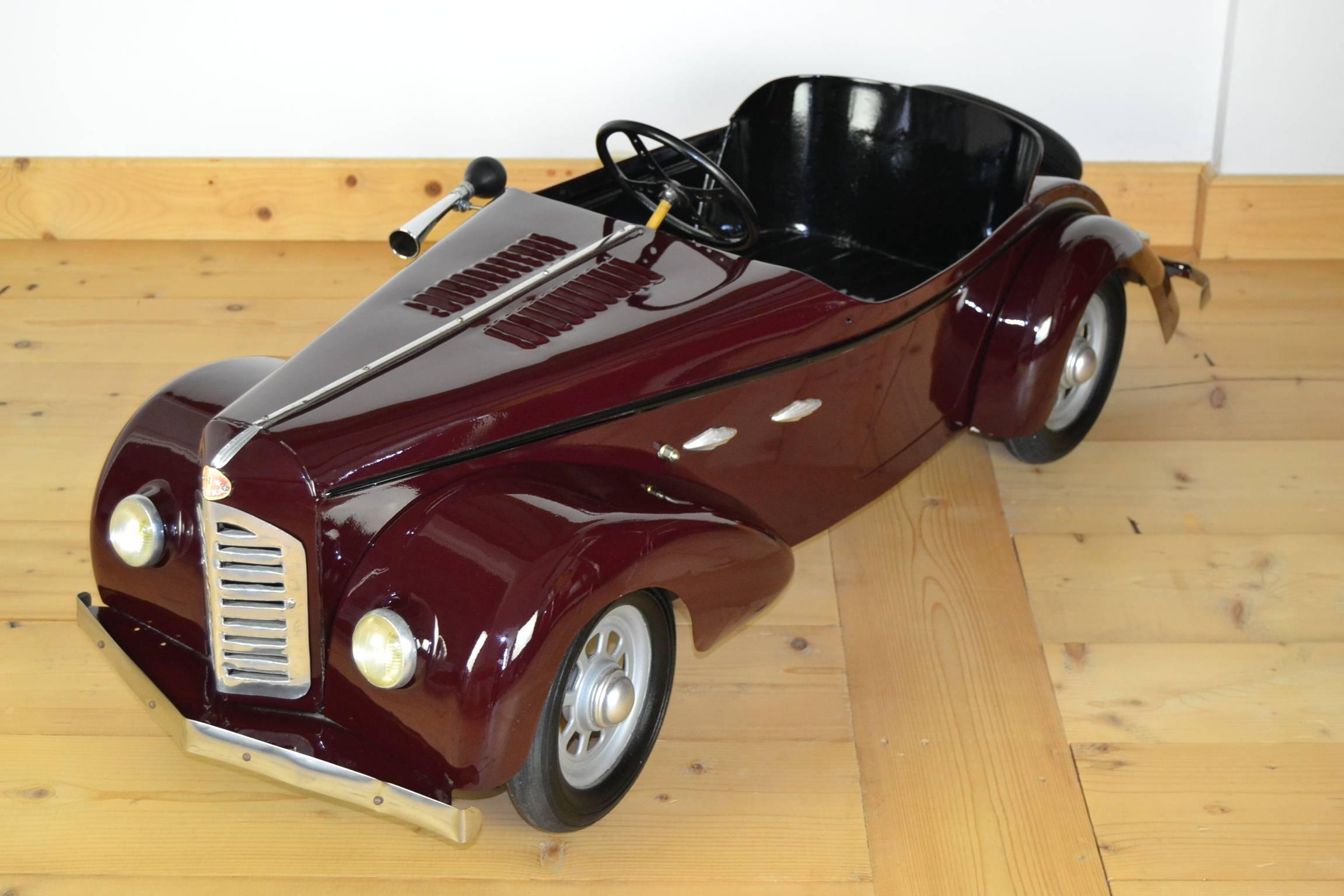 Elegant Pedal Car Toy made by Eureka France.
Attributed to the classic car Delahaye 135. 
Model Junior 48 / number 3 - 1 seat car.
circa 1950.
It's the most luxury one of this serie with lights in front and at the back, bumpers, spare wheel, rubber