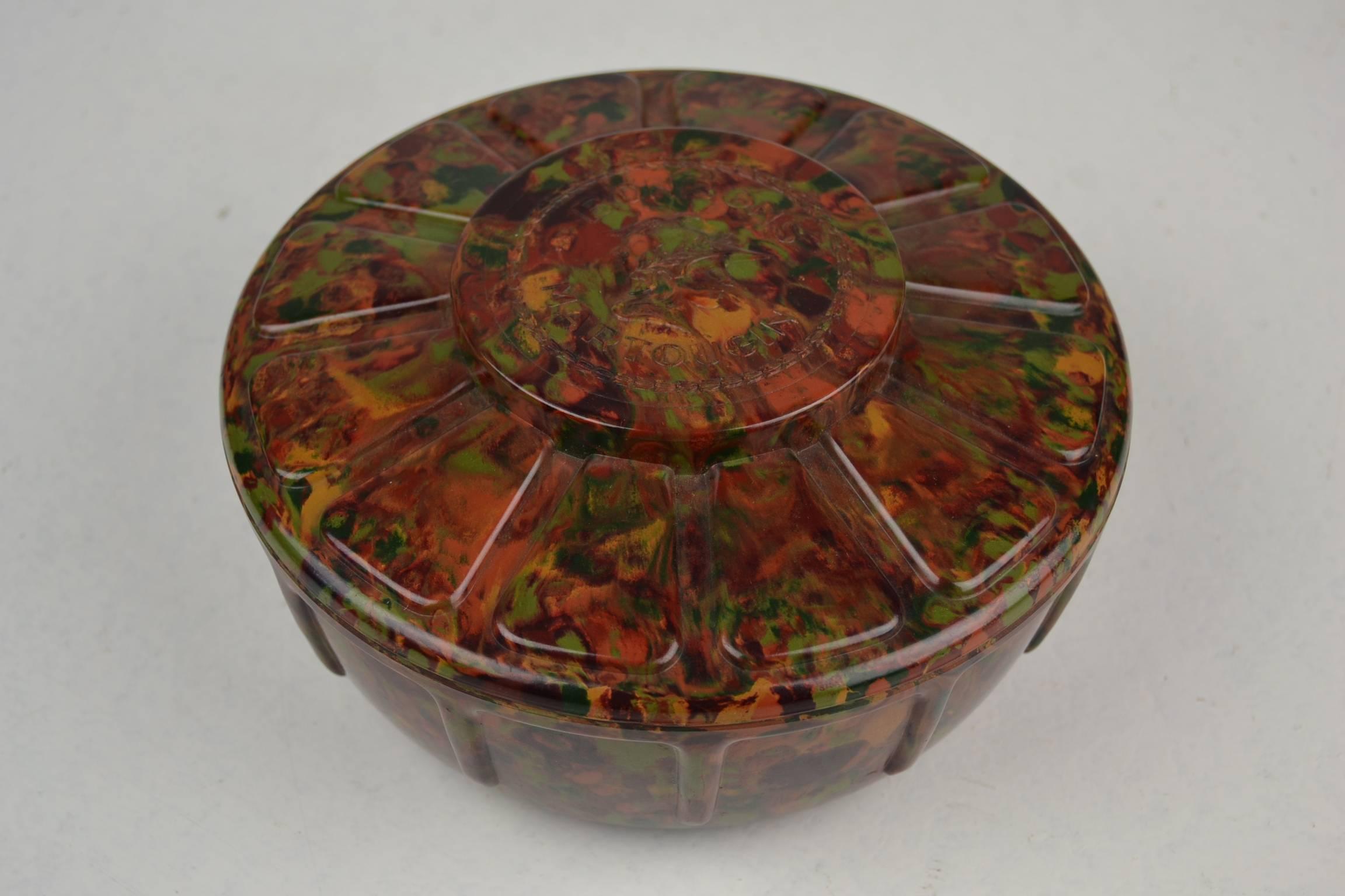 Stylish  Art Deco Bakelite Bonbon Box for the Belgian Chocolate Brand Martougin. 
This Storage Box for Chocolate dates from the 1920s and is made in the beautiful Autumn Colors red, brown, green, orange and yellow with a Flamed Pattern. On the lid