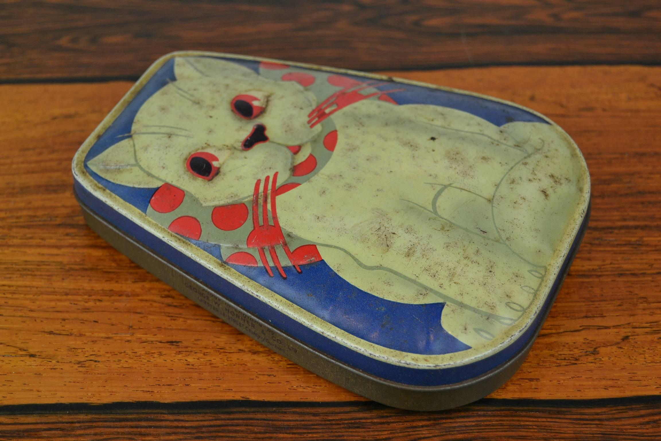 Cute vintage toffee tin box with a cat.
George W. Horner and co LTD - England, Chester le street. 
Art Deco Embossed Tin Box with white cat - puss on blue bottom. 
This serie of tins started in the 1930s. 
It has the combination of the colors white,