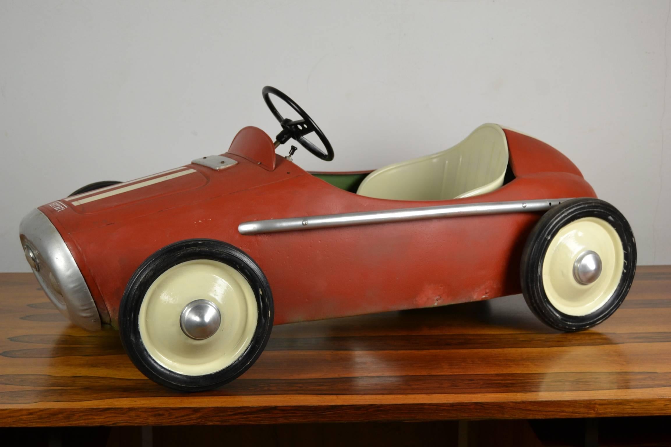 Vintage children's Ferrari racer pedal car type Indy - made by M.G. / Morellet et Guérineau France - from the late 1950s.
This vintage toy car has an old repainting, frosted colors red with white stripes.
For pedal car collector - decoration and