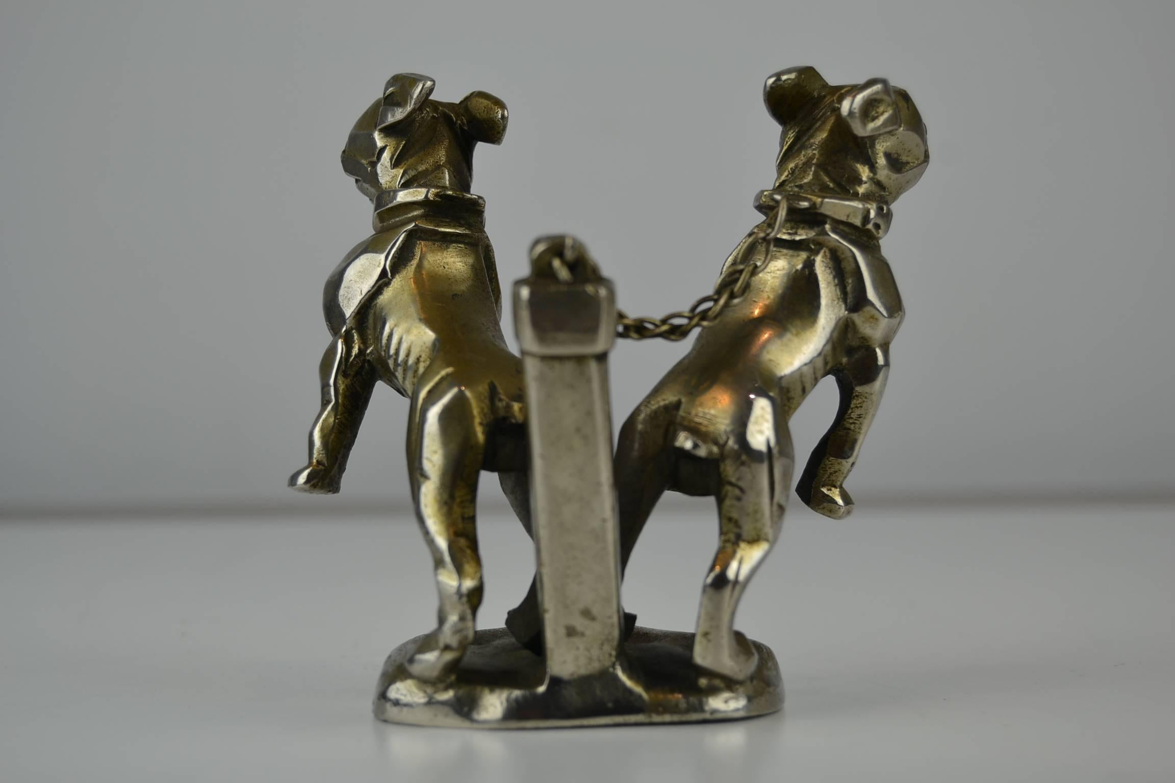 Exclusive Art Deco hood ornament, Truck Mascot with two metal jumping cubist Bulldog figurines on chain in the style of Marvel, early 1920s.
Limited edition Car collectables, not signed.
Material nickel-plated bronze.

The Mascot with three