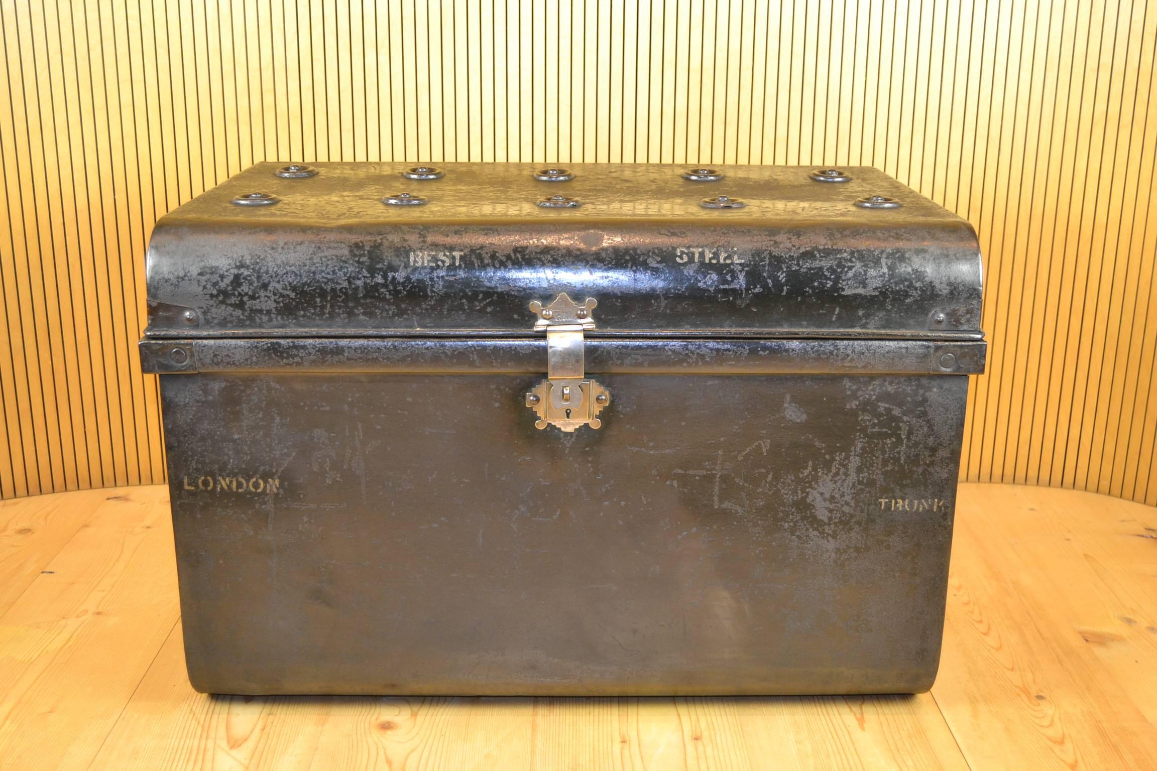 Gorgeous large English antique metal travel trunk, travelling trunk.
Best steel trunk London.
Black painted exterior floor trunk with knobs on the top to protect the trunk when others were stacked on top. Has corner brackets and a steel lock, no