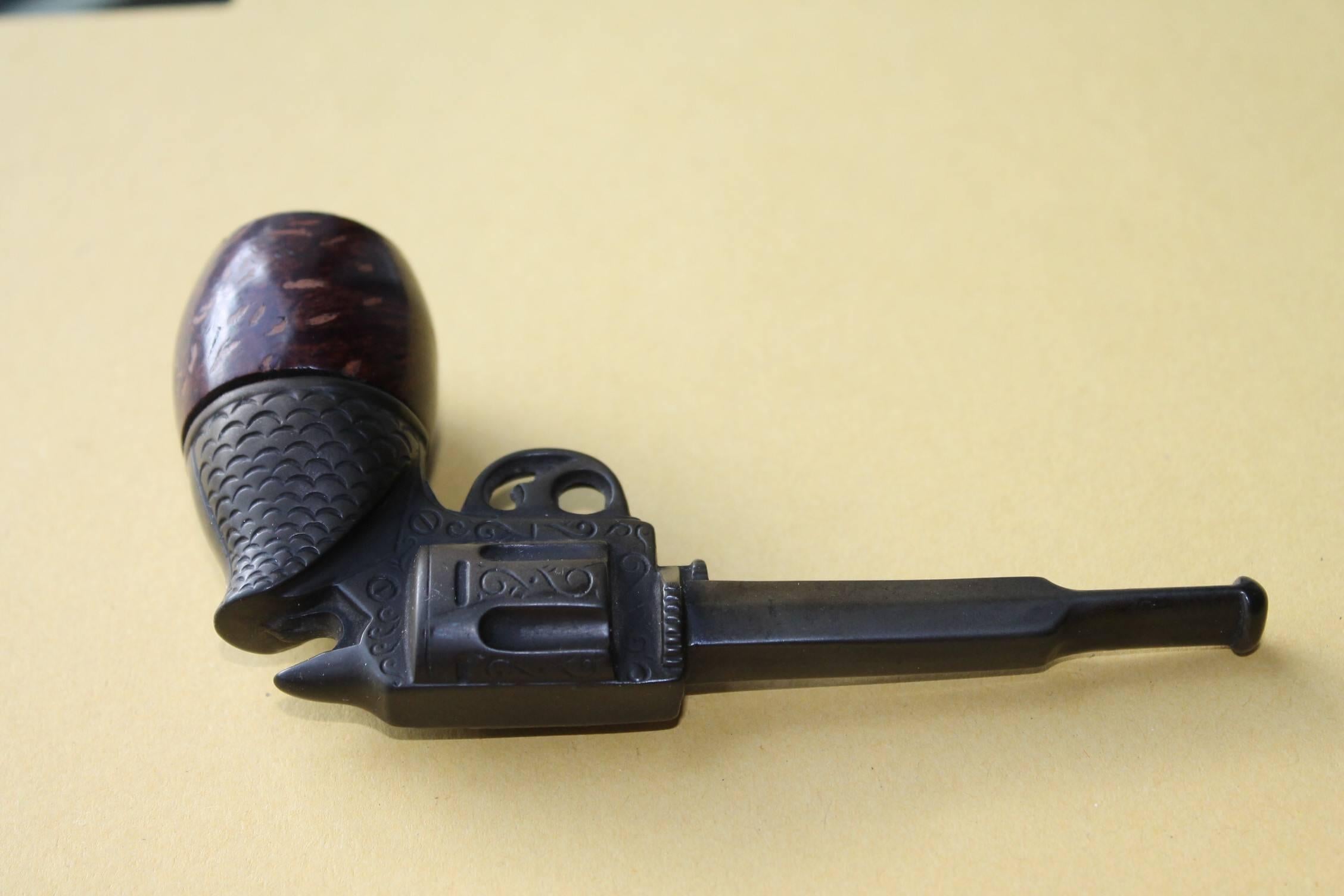 Extra Ordinary Gun - revolver smoking Pipe in a kind of Bakelite with briar wooden  Bowl - Pipe. Has the shape of a little Antique Colt Revolver.  Genod Pipe made late 20th century , circa 1970s.
A finely modelled bakelite wild west revolver with a