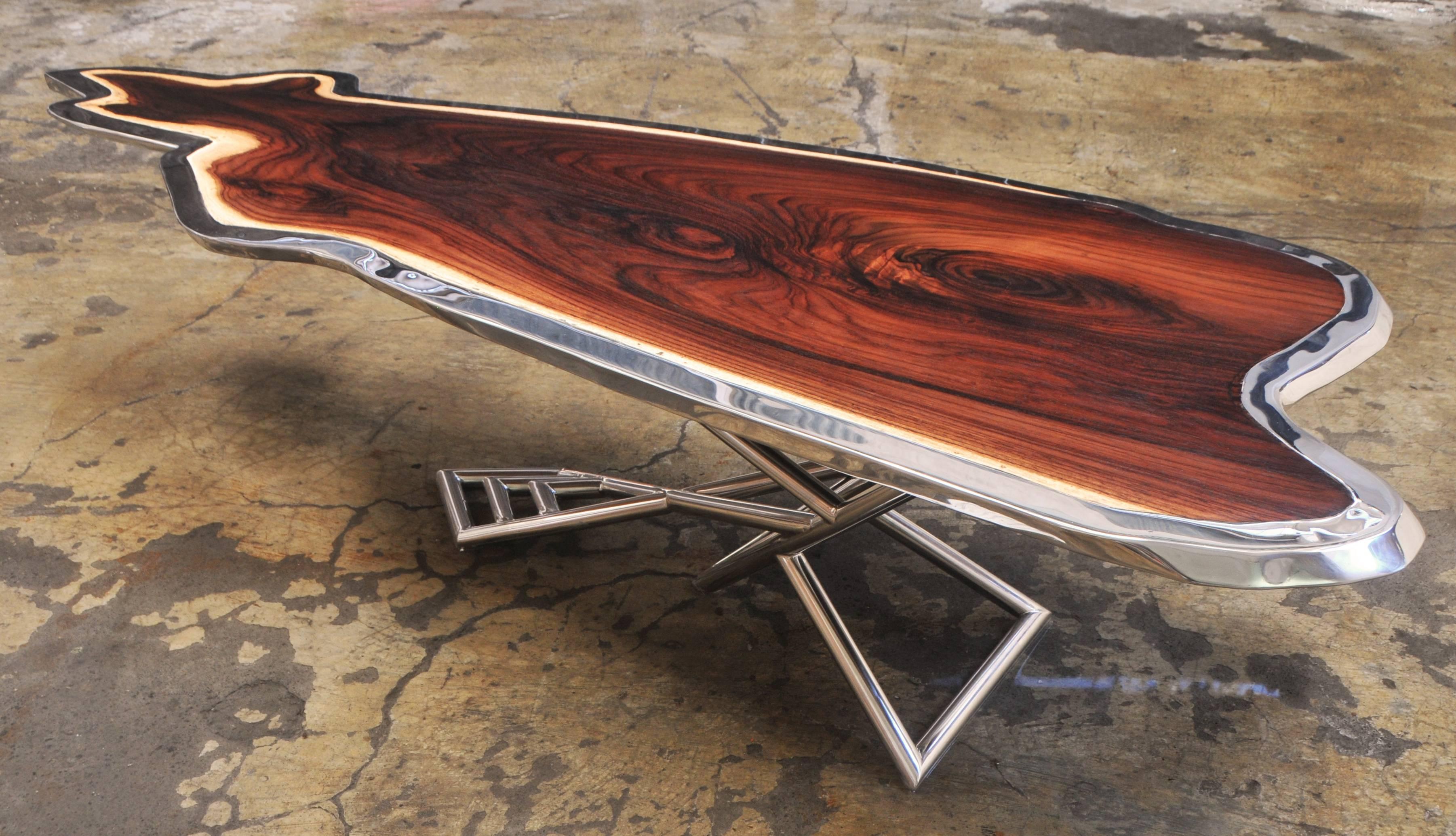 Unique coffee table made with rosewood and mirror polished stainless steel. This piece has an image of a kangaroo shaped by nature. The stainless steel lining perfectly enhanced the kangaroo shape.

Designed by Bruno Helgen and manufactured in his