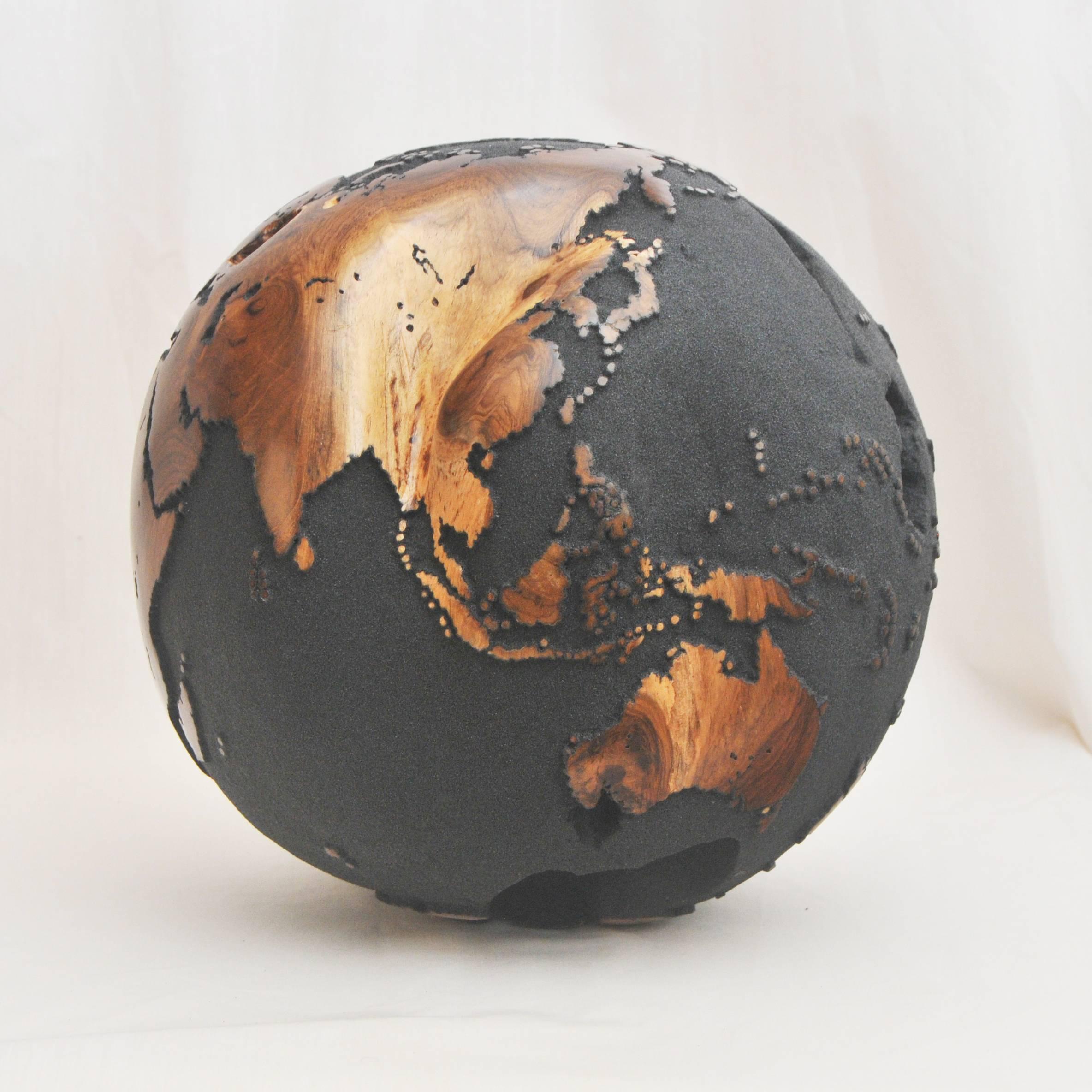 One of a kind globe
Hand-carved in a solid piece of teak root
Finish: Volcanic sand
Mounted on turning base.
 