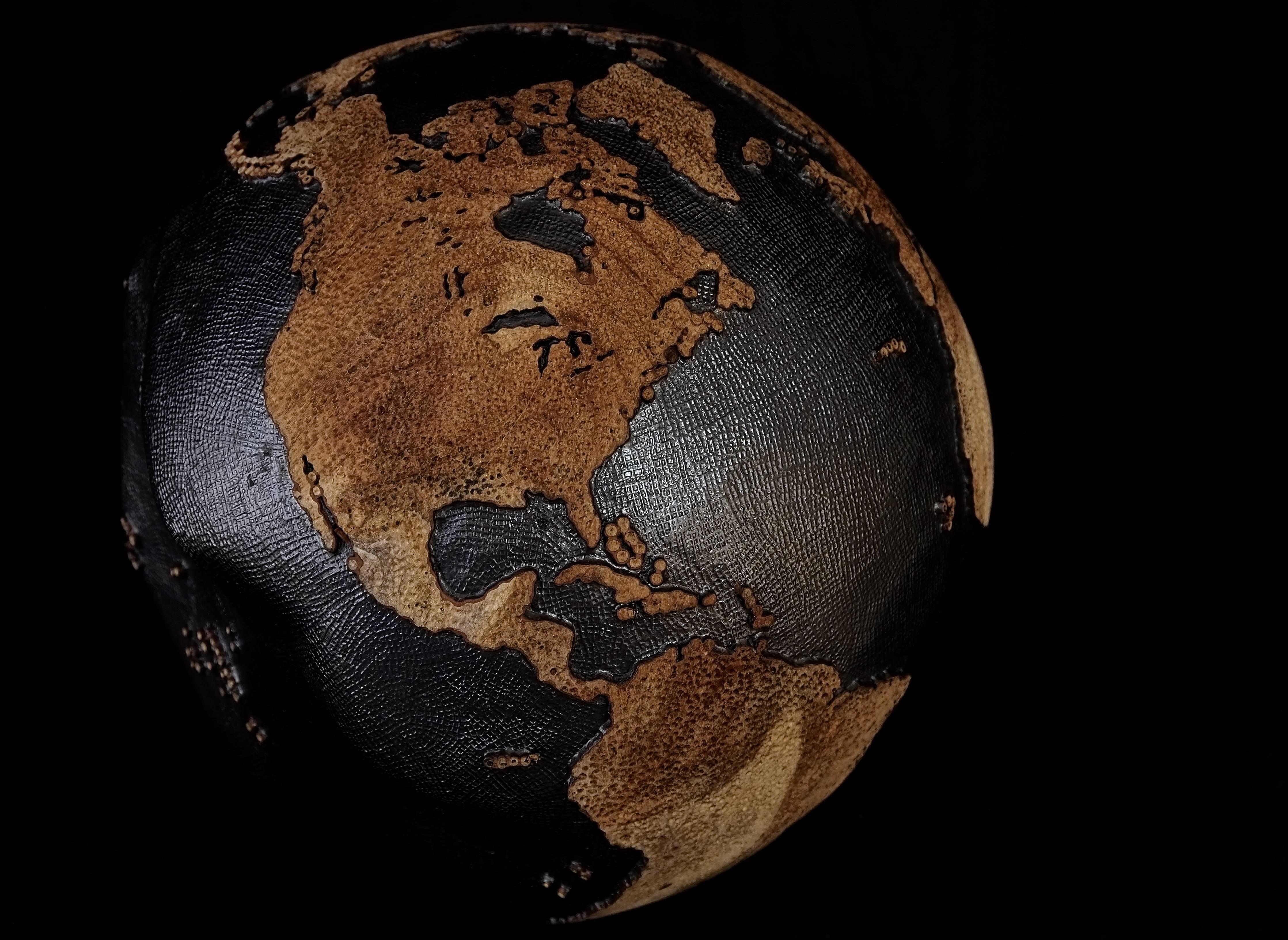One of a kind teak root globe 30 cm hand-carved / mounted on a rotative base
Hammered copper inlay on oceans / finishing graphite
Skin hammered on continents / finishing natural. 

      