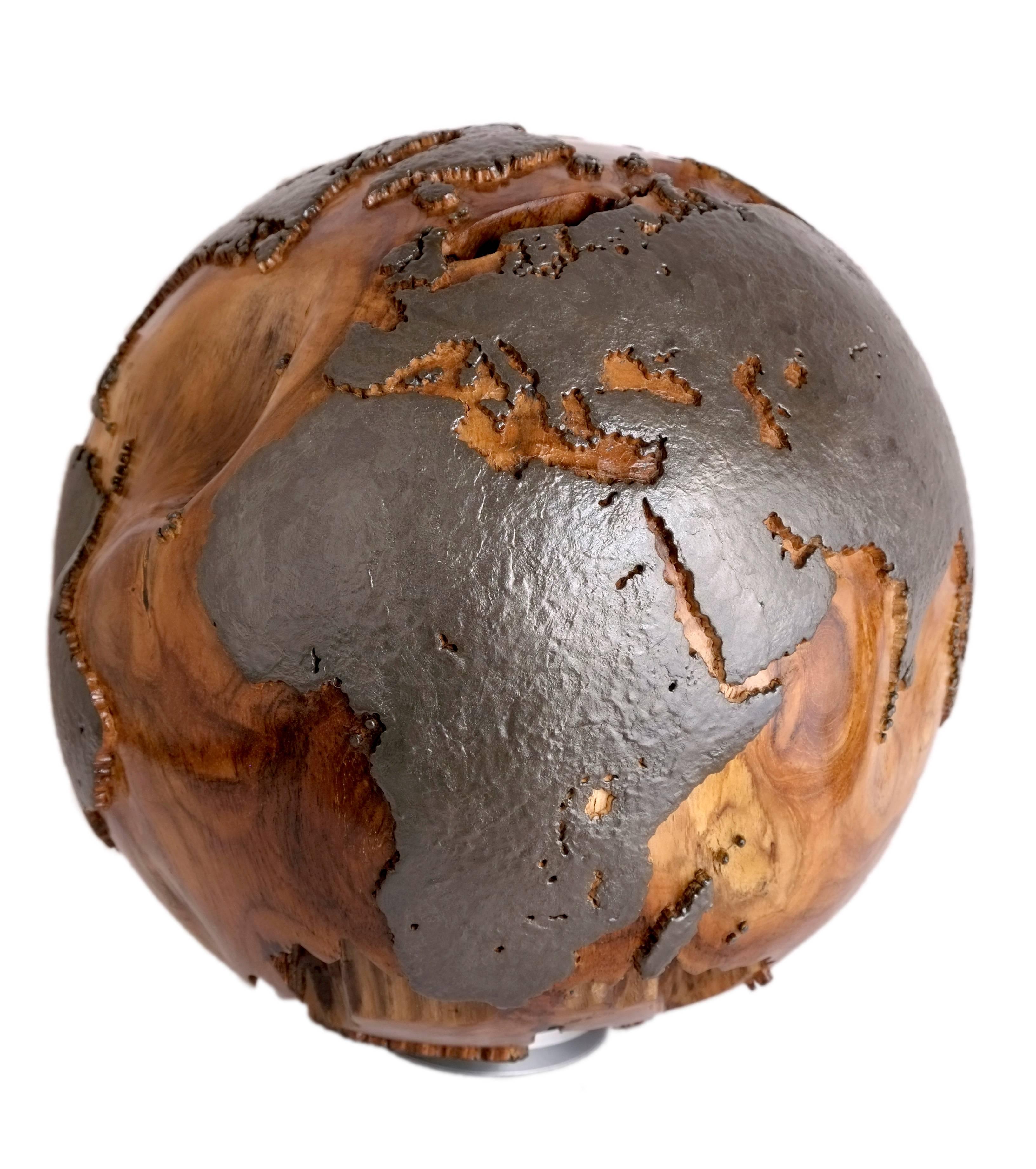 Globe terrestre en teck sculpté à la main avec des finitions en métal sur les parties continentales. Ce globe présente des crevasses et des fissures naturelles remarquables sur le dessus et le dessous. Une pièce absolument