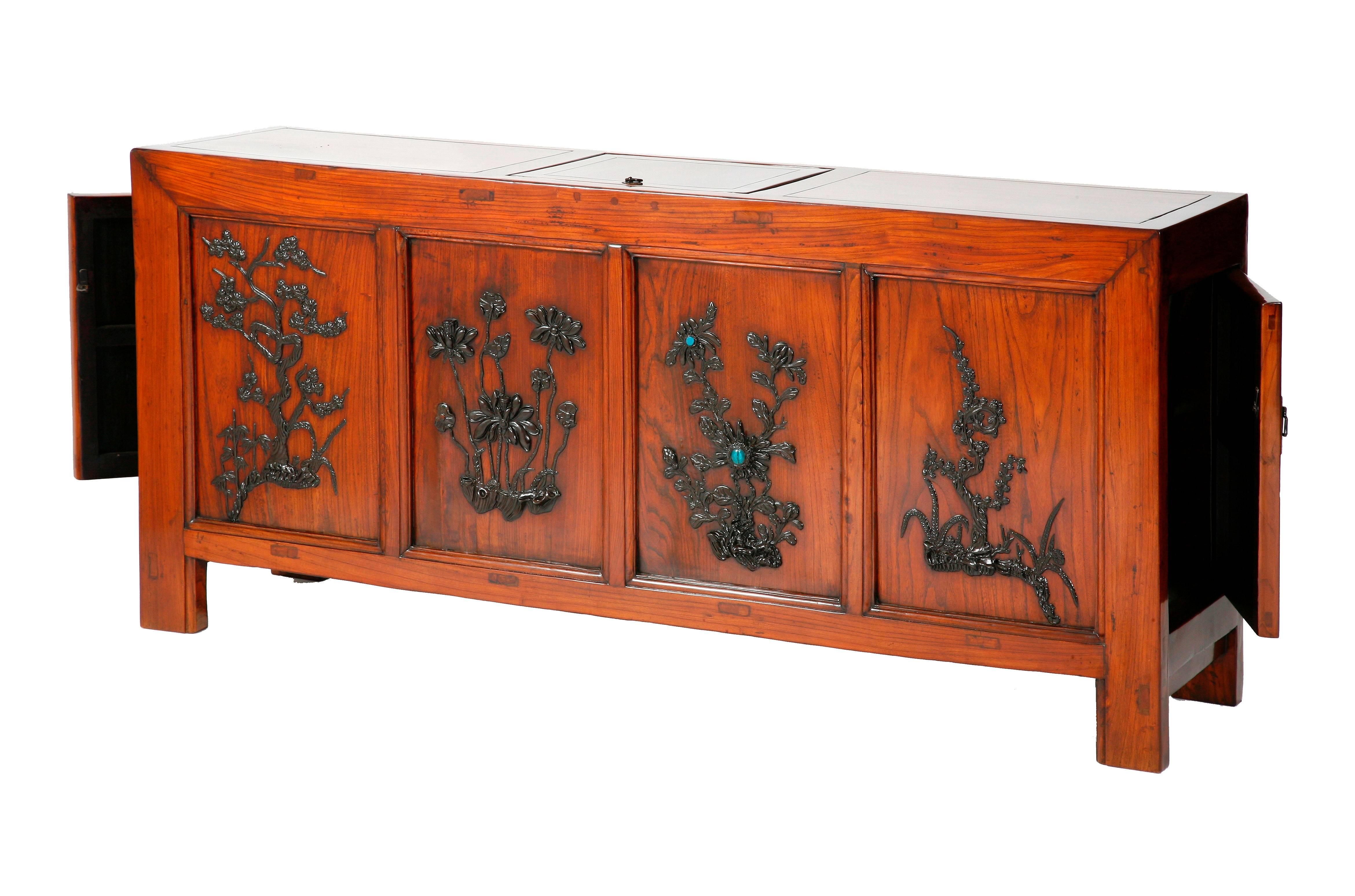 The unique square corner coffer with a lift top and doors on both sides for accessing to the storage spaces, rectangular-sectioned frame members carved with molding, the front panels inlaid with ebony carvings of pine, lotus, chrysanthemum with