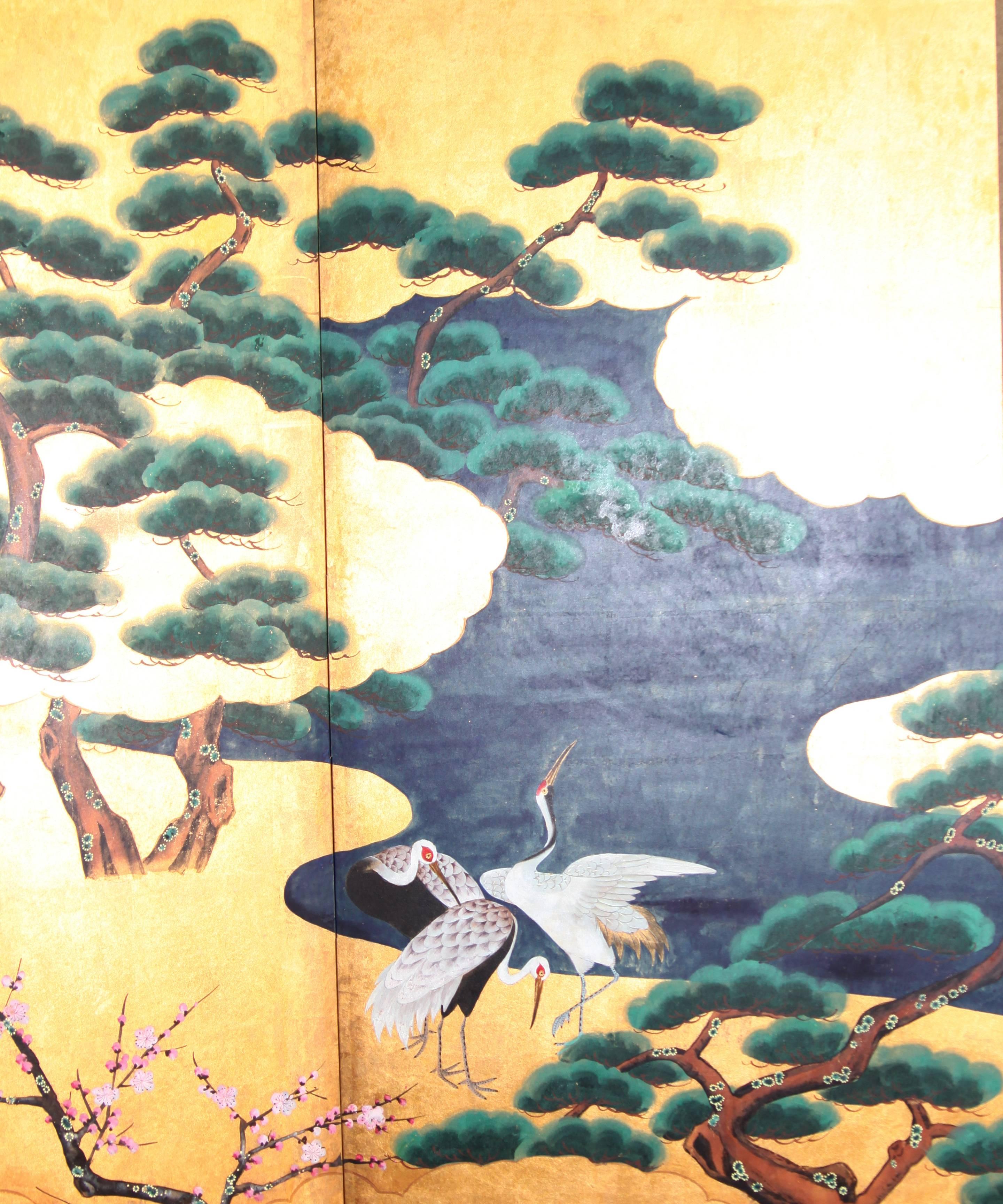 The Cranes by The River painting of this four-panel screen is hand-painted in watercolor, on squares of gold leaf which are applied by hand to the paper base over carefully jointed wooden lattice frames. Lacquer rails are then applied to the