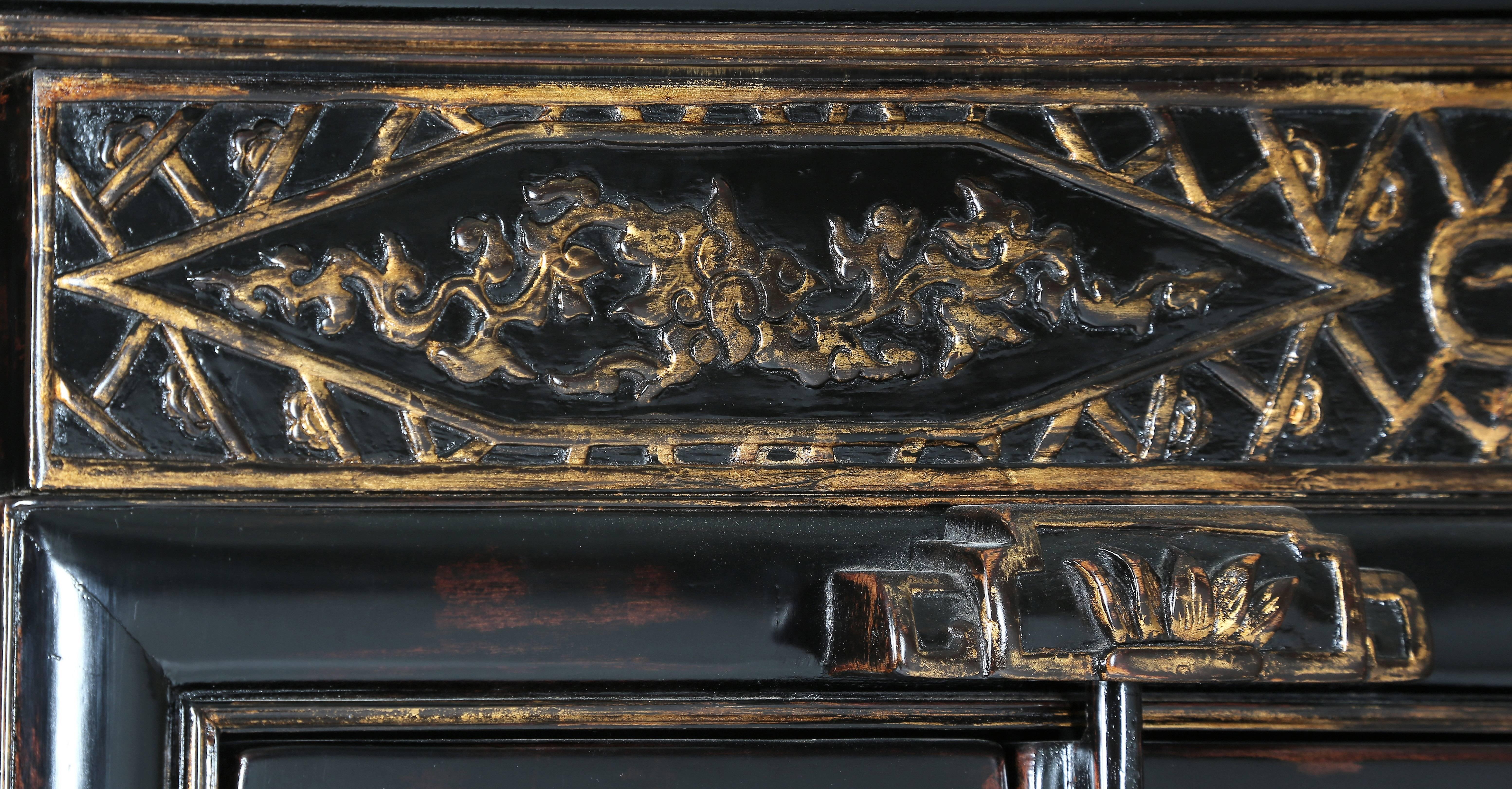 This charming cabinet featuring a molded ice-plate top edge above a high waist, decorated with gilded floral relief-carving within gilded geometric borders, surrounded by cracked-ice motif on the front and embossed geometric panels on the sides, a