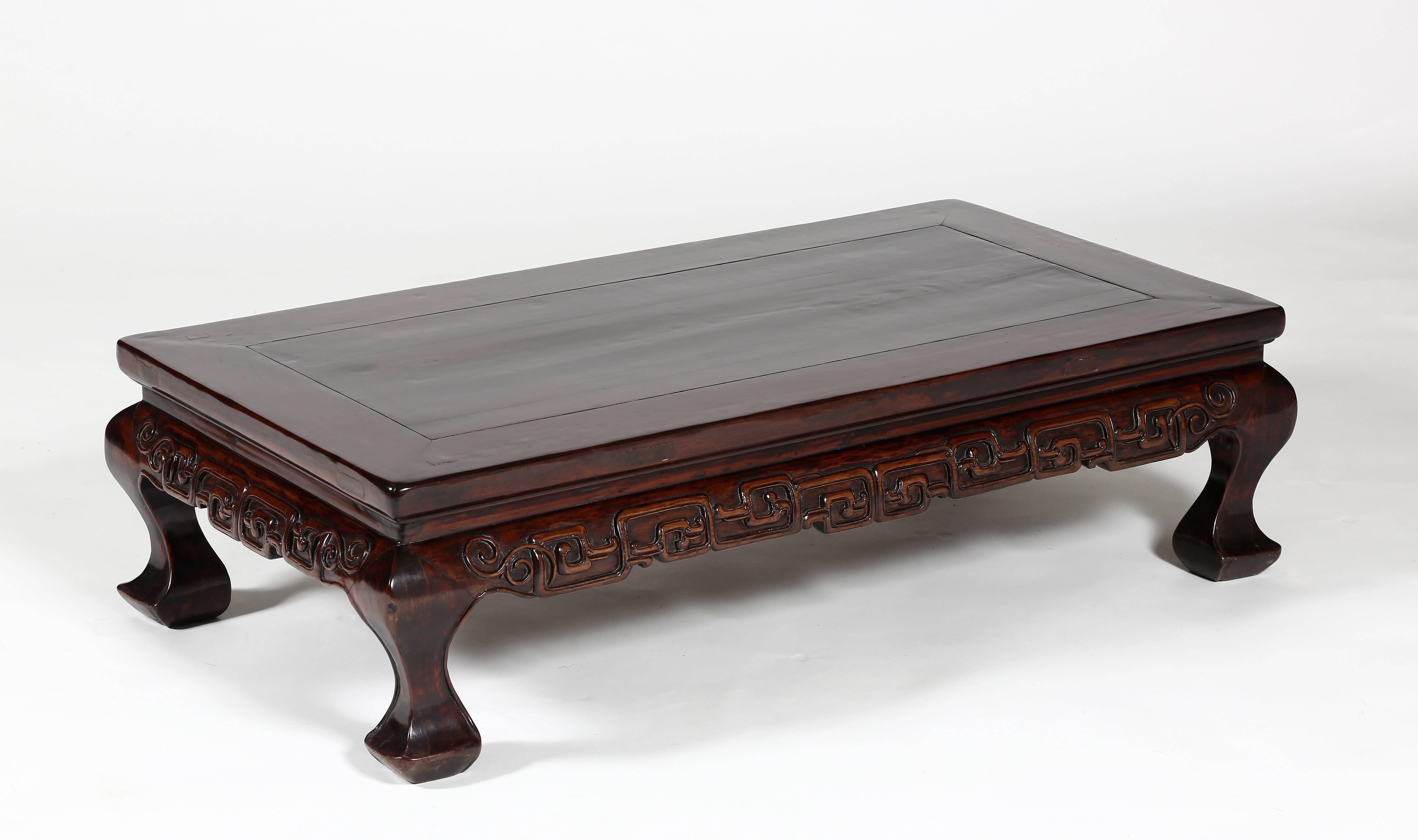 The wonderful low kang table with a floating top panel, enclosed within a frame with molded ice-plate edge, above a waist, an outward-curving apron relief-carved with rectangular scroll work, supported on cabriole legs
Lacquer with patina over