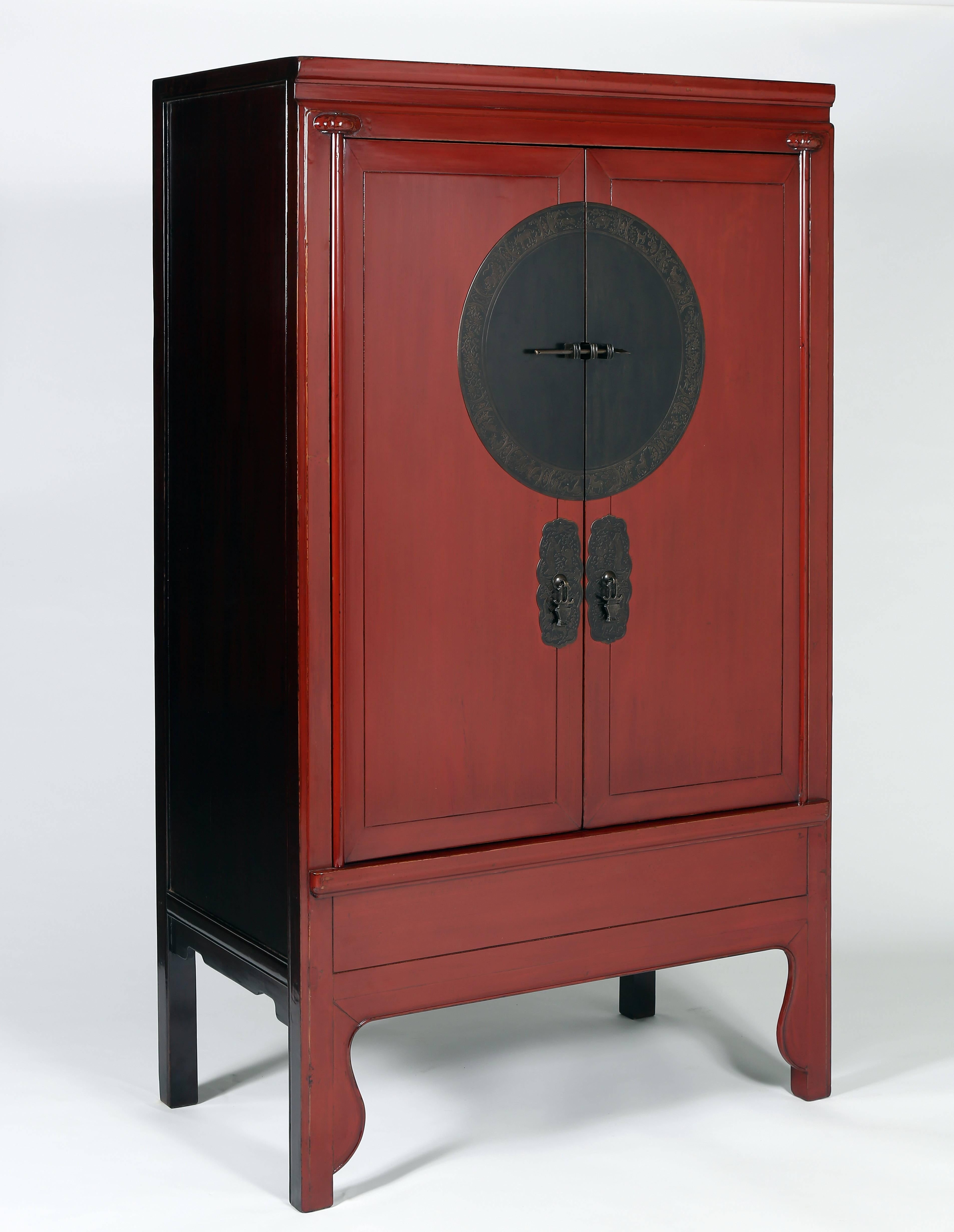 The cabinets with a molded ice-plate top front edge, supported by rectangular-sectioned side posts, a pair of paneled doors, fitted with decorative round brass lock plate, opening on wooden carved pumpkin shaped hinges to reveal a top shelf forming