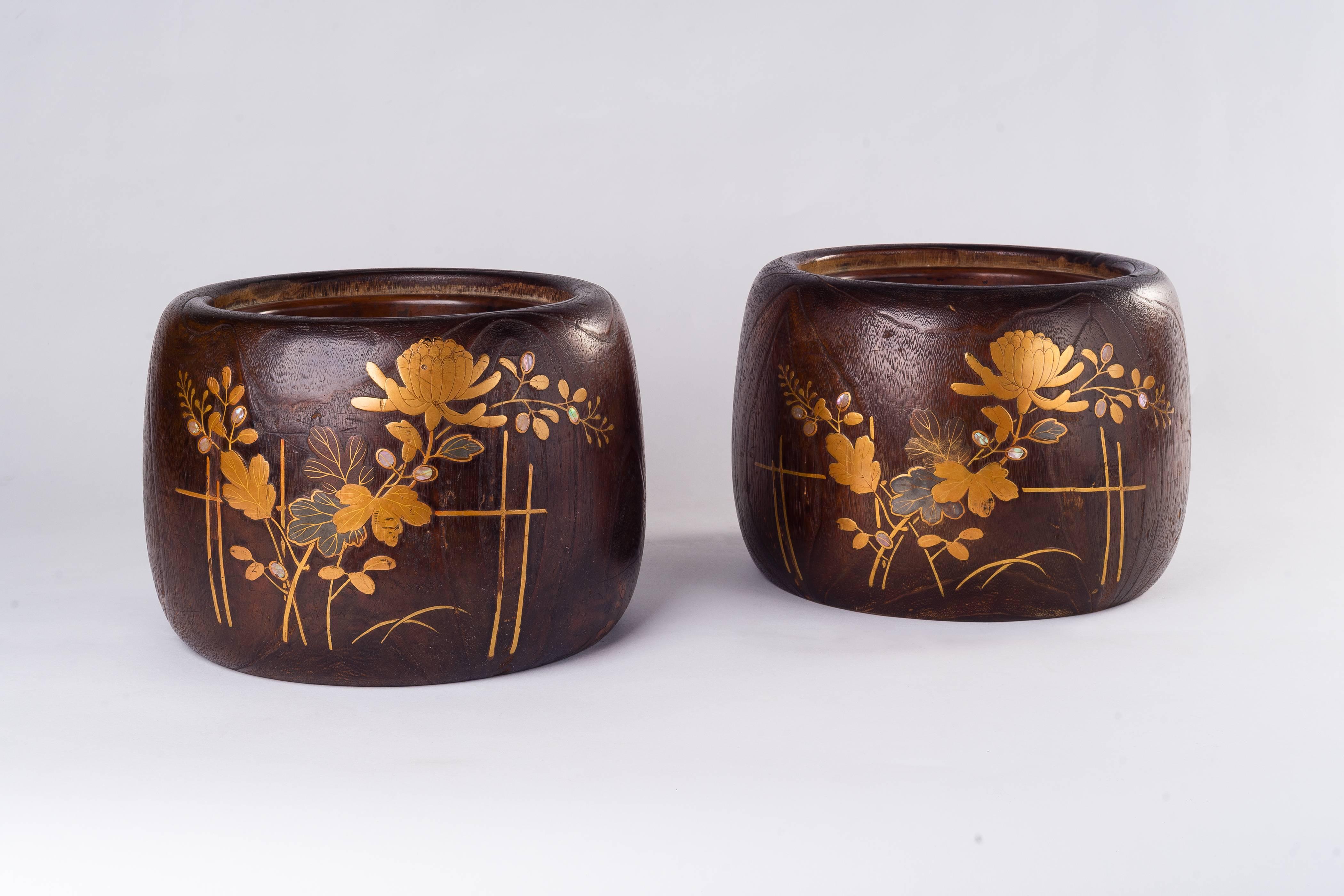 The handcrafted pair of Japanese wooden hibachi (fire bowl) is finely decorated with chrysanthemum tree and foliage, and executed meticulously in hand-worked make gold lacquer work with brass and mother-of-pearl inlay. The circular hibachi lined