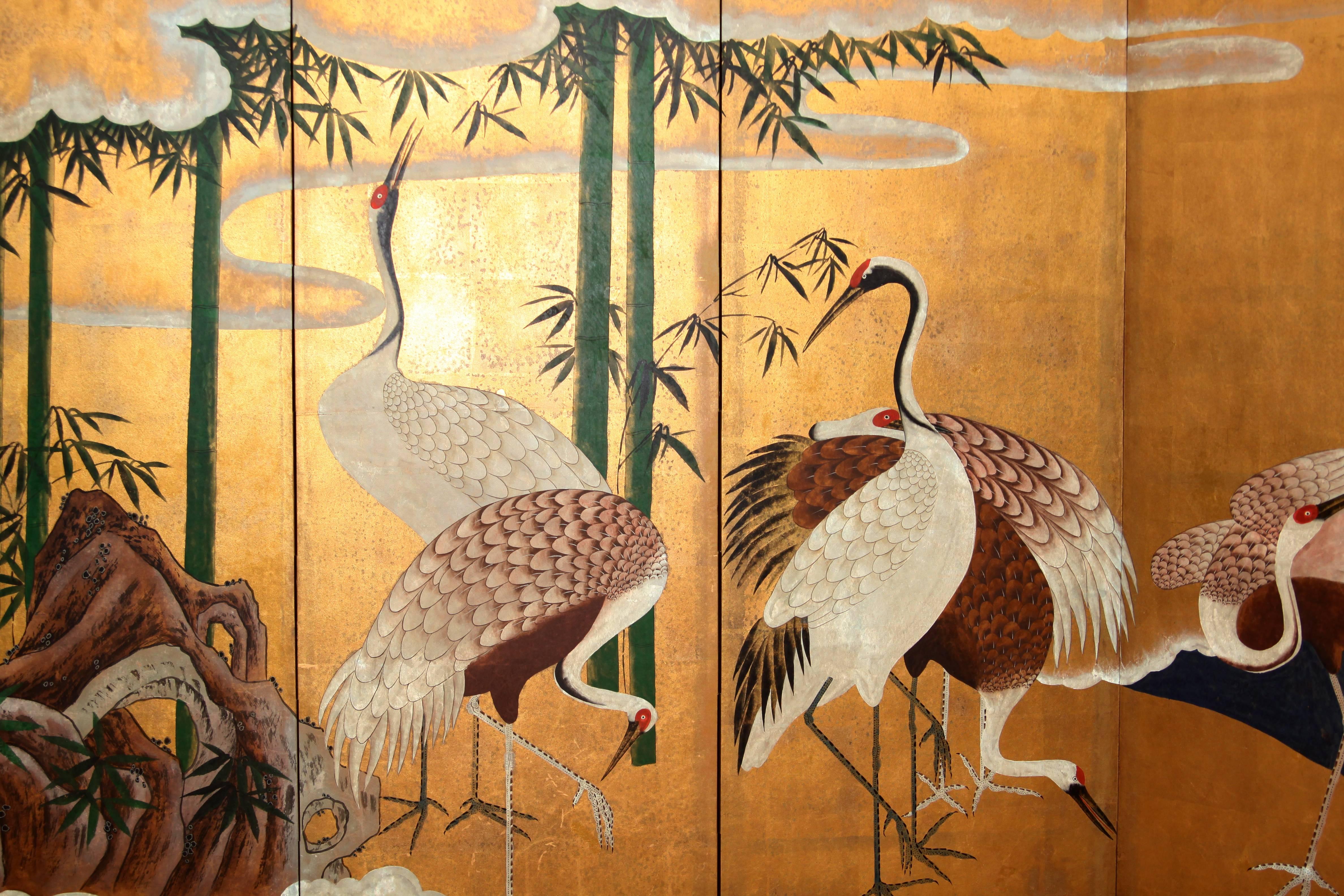 The painting of gathering of cranes of this six-panel screen is hand-painted in watercolor, on squares of gold leaf which are applied by hand to the paper base over carefully jointed wooden lattice frames. Lacquer rails are then applied to the
