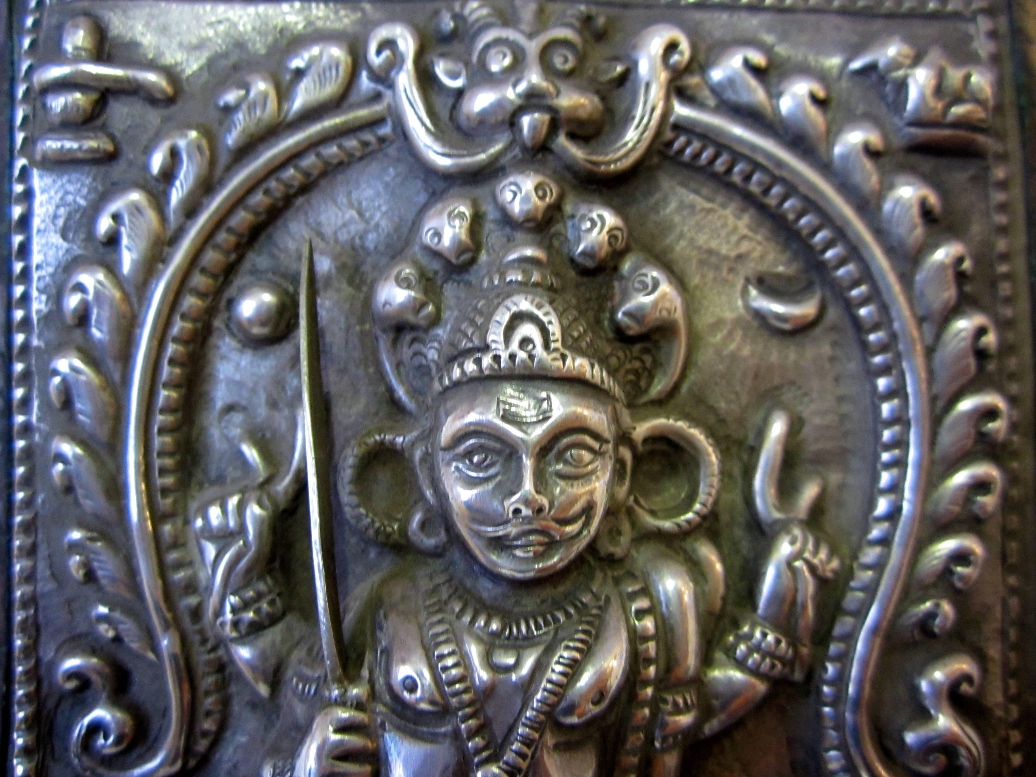 Indian silver and copper ritual plaque from Karnataka.
The Hindu warrior god Virabhadra is standing and holding sword, mace and shield. Two attendants are at the side.