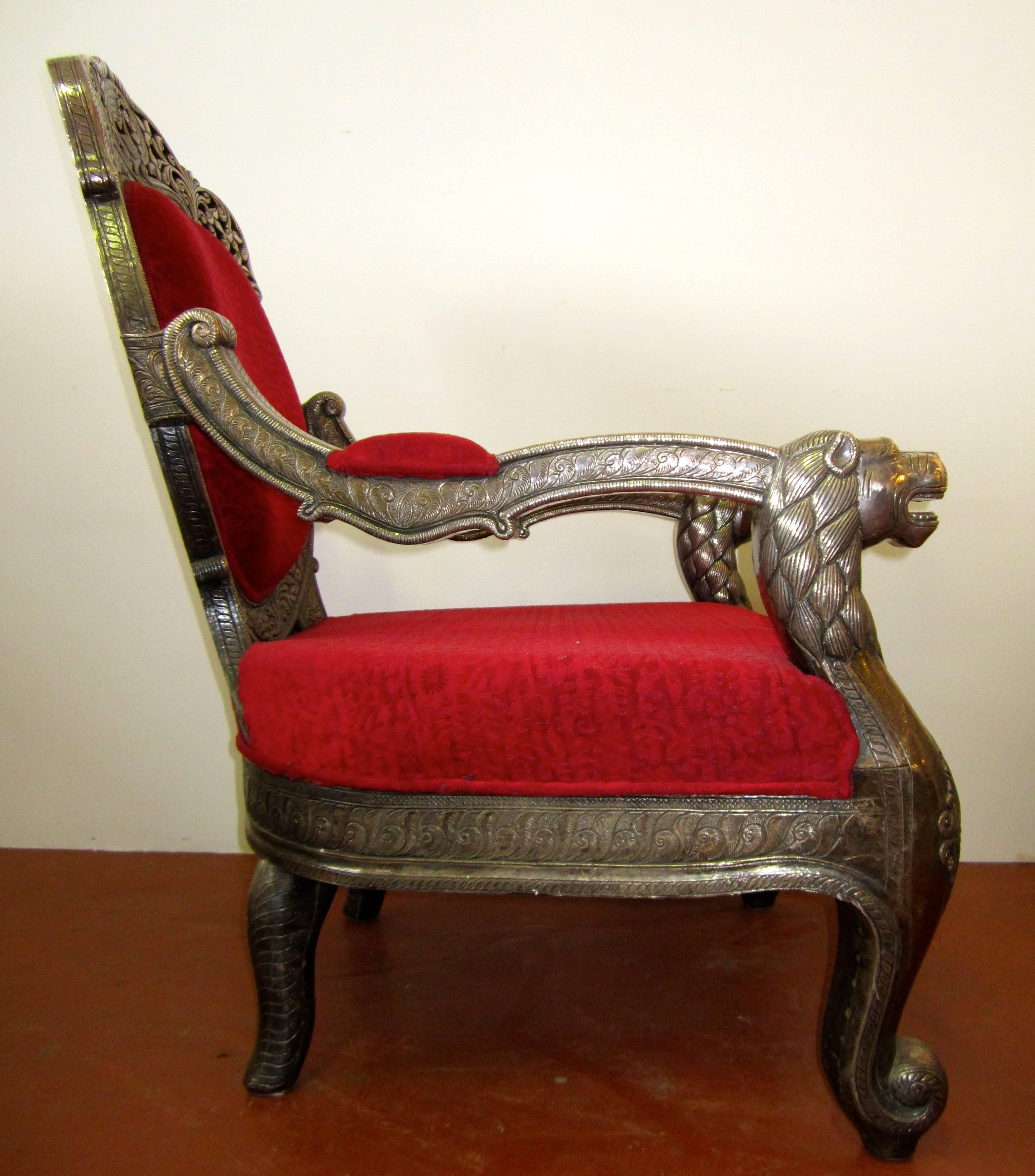 Indian carved wood and silver covered armchair with lion heads, peacock and leaves motive. India 1950 circa.