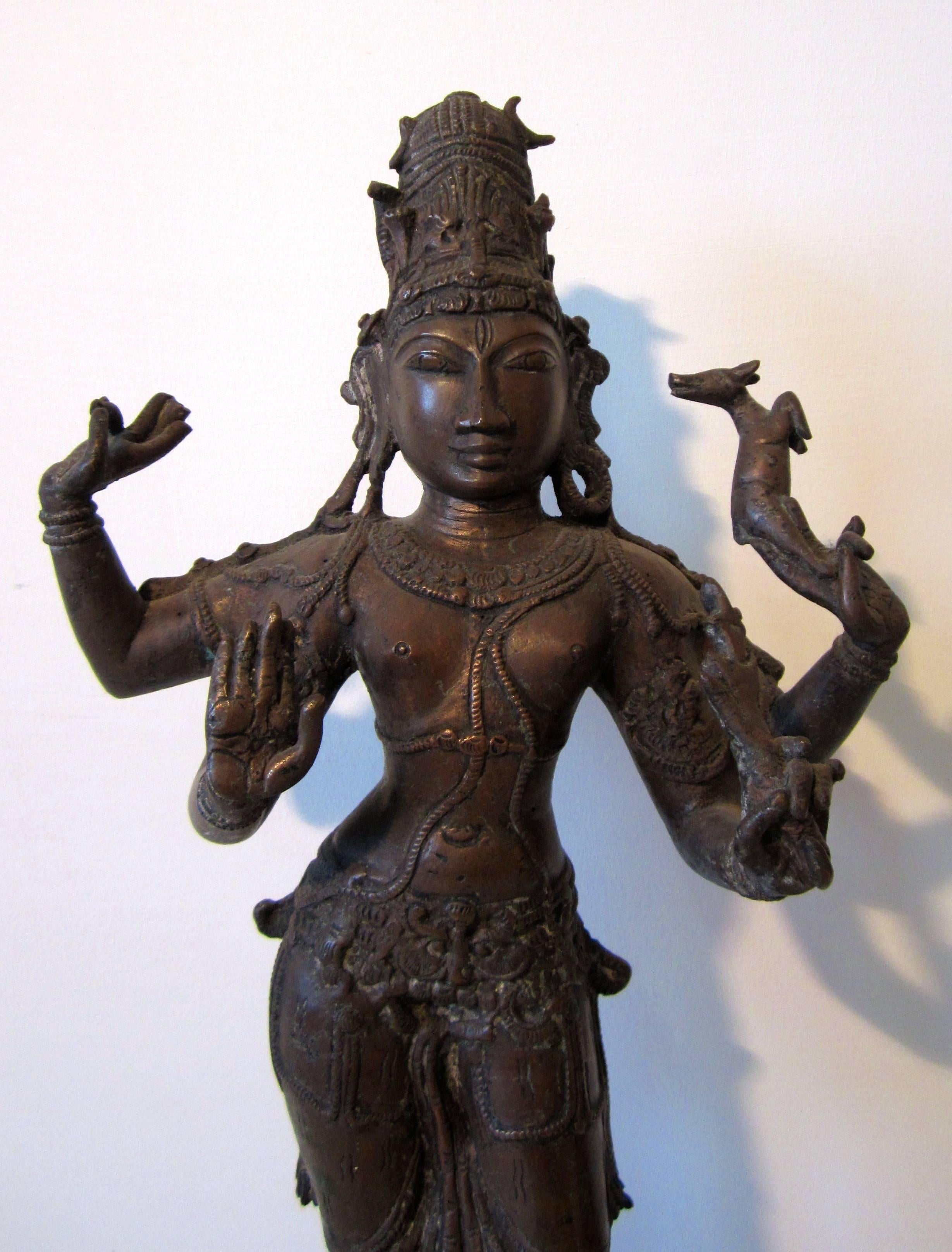 A large bronze figure of Shiva standing in the classical style of South India.