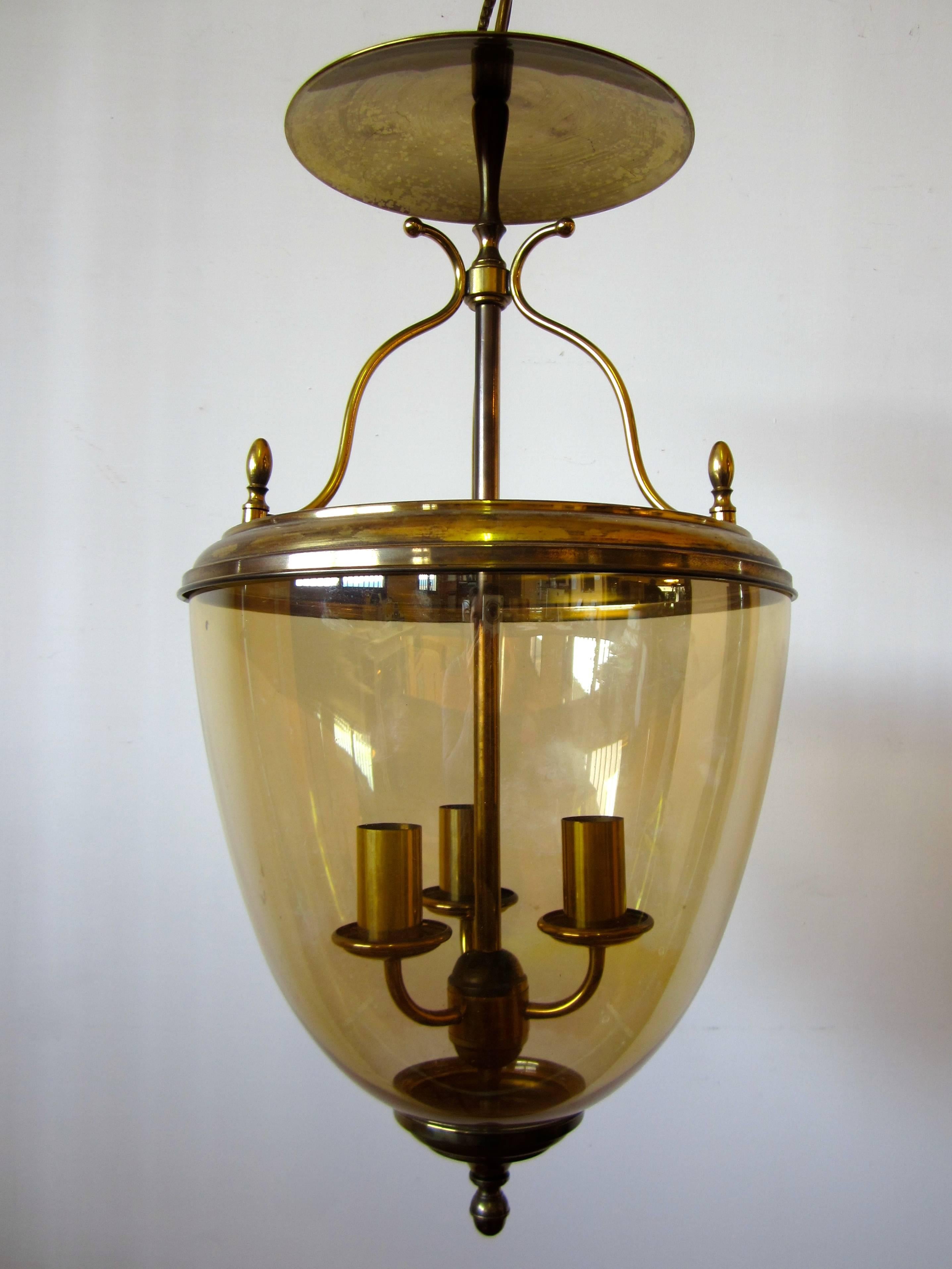 Neoclassical gilt brass lantern with amber glass ball.