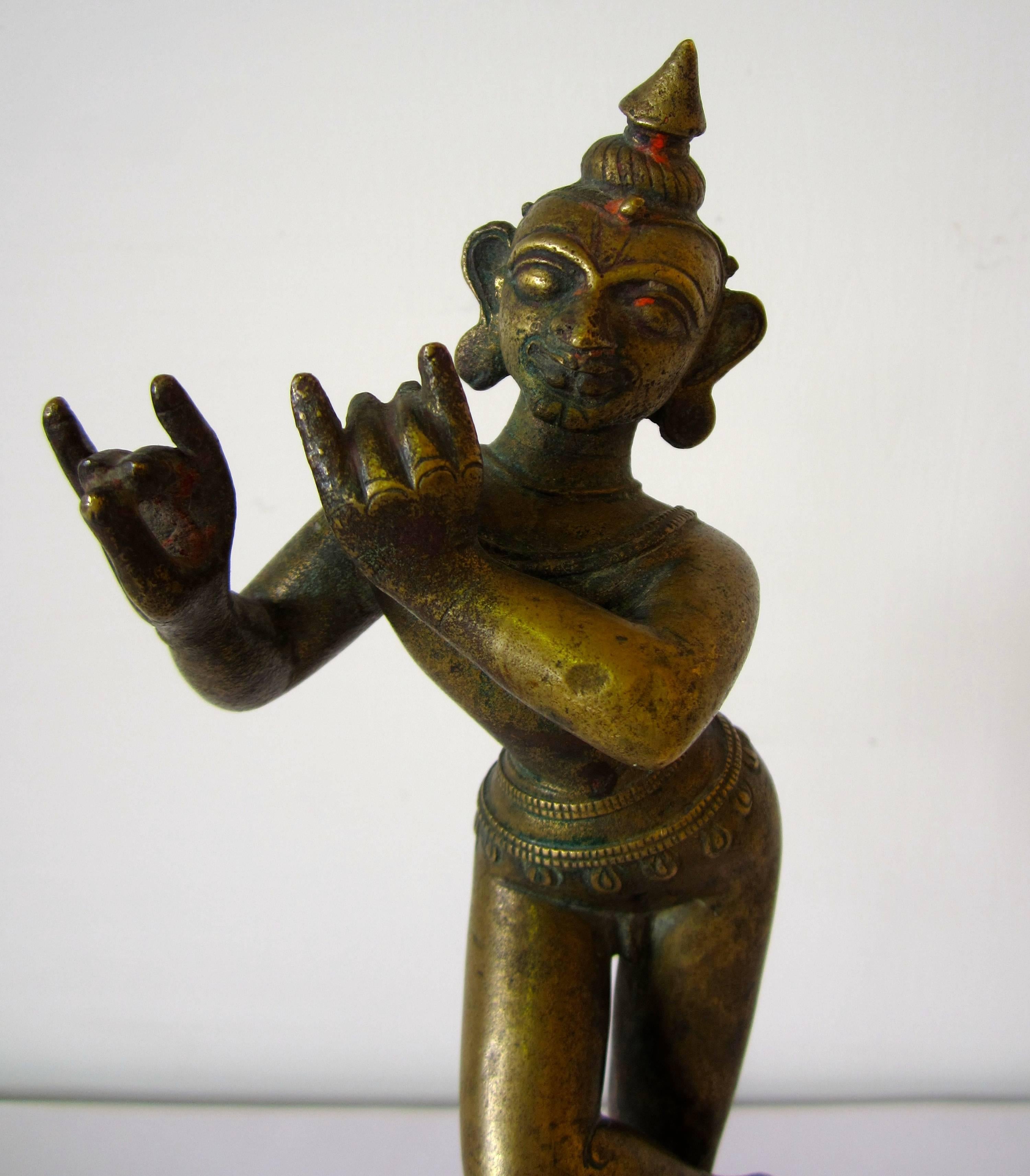 A bronze figure of Krishna Venugopala, standing on a lotus base with ankles crossed and hands as if holding a flute, with jewelry and belt. Orissa or Bengala, 18th century.