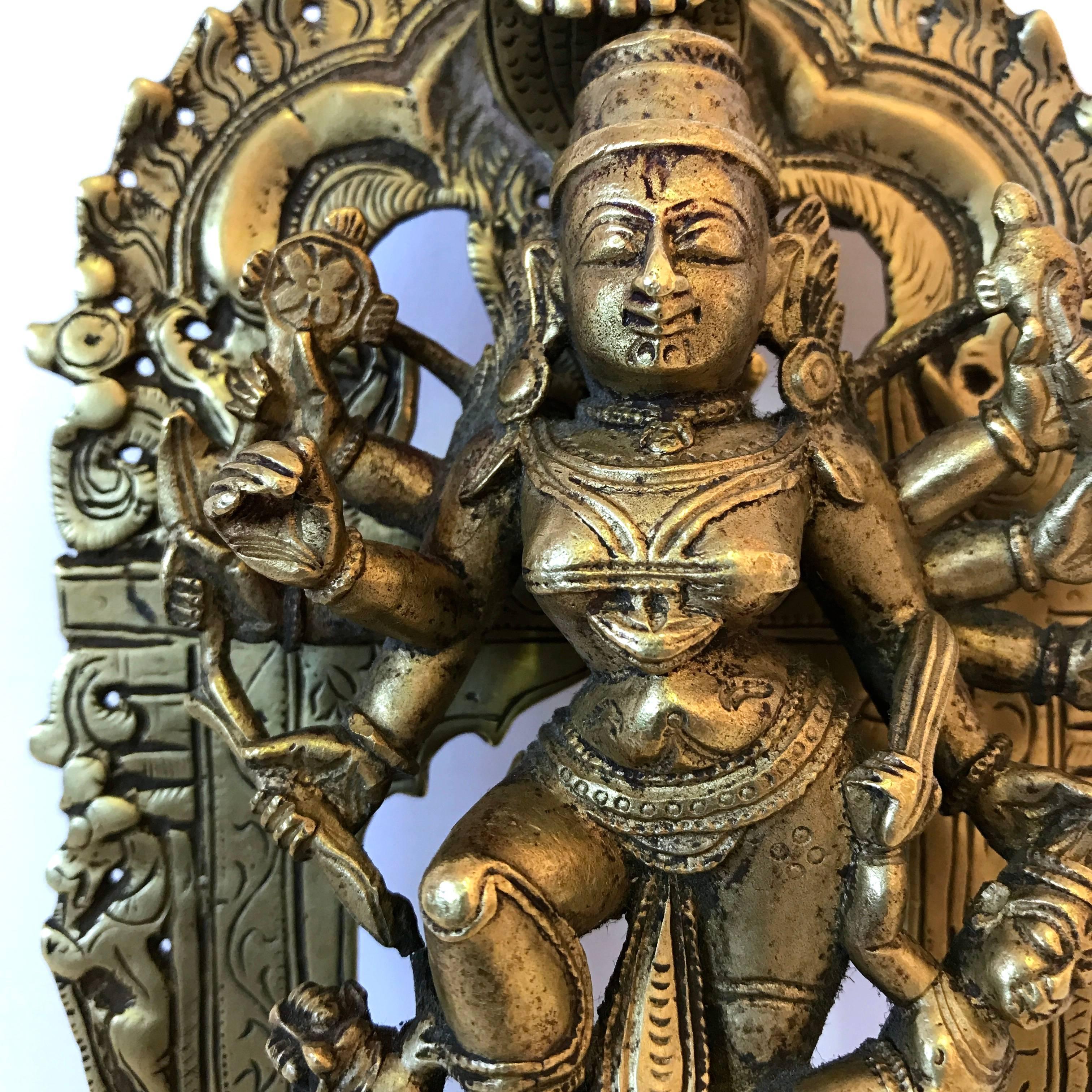 A bronze figure of Mahishasuramardini (killer of the buffalo demon). The goddess Durga holding various weapons in height arms, kills the demon Mahishasura as he emerged from the vanquished buffalo, with the help of her lion. Maharashtra or central