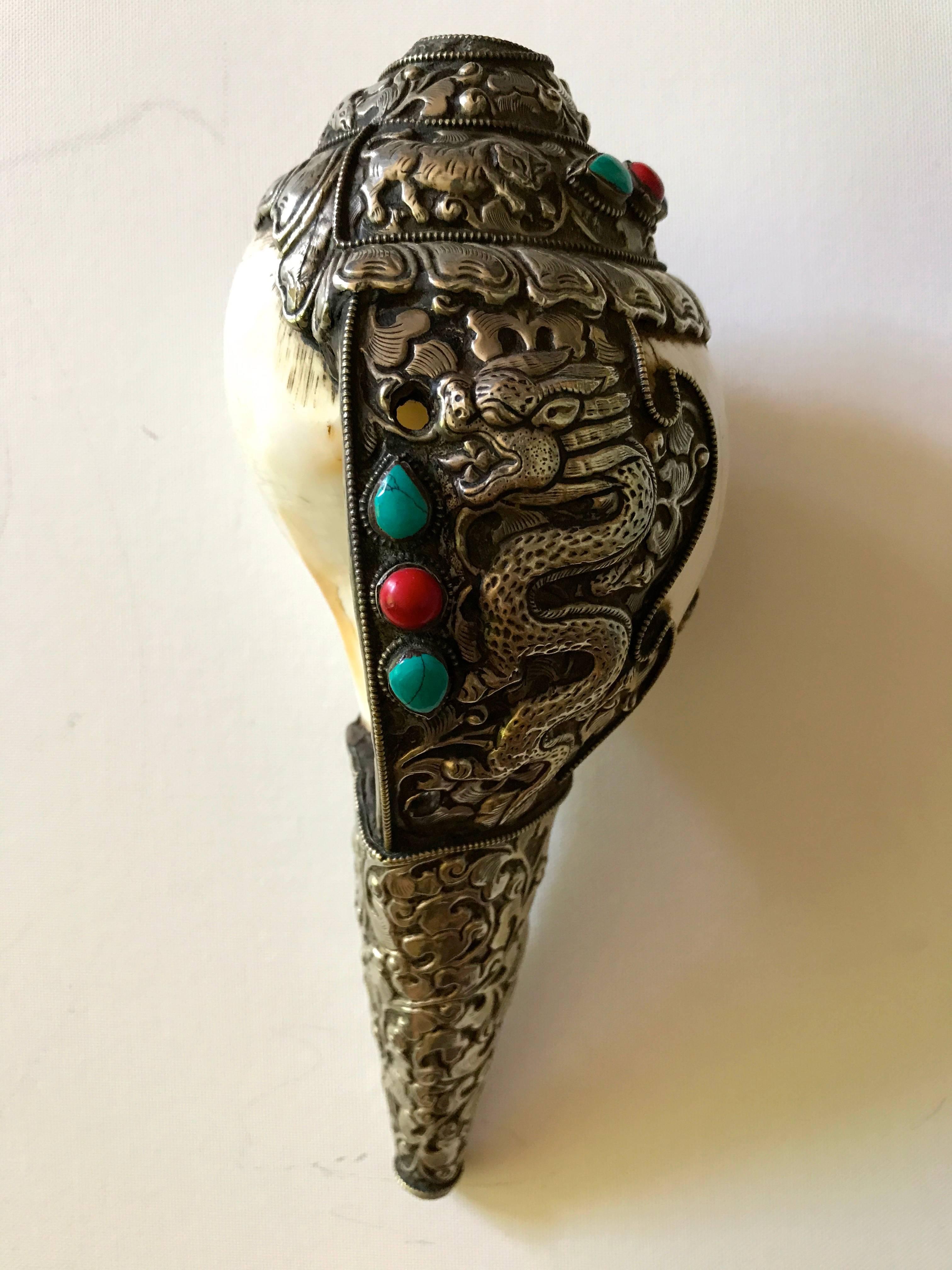 Tibetan ritual conch shell. Made with a Shankha (turbinella pyrum), that is a holy shell with religious importance in Hinduism and Buddhism, is used as a trumpet in rituals. The shell is part covered with repoussè and fine chiseled silver with