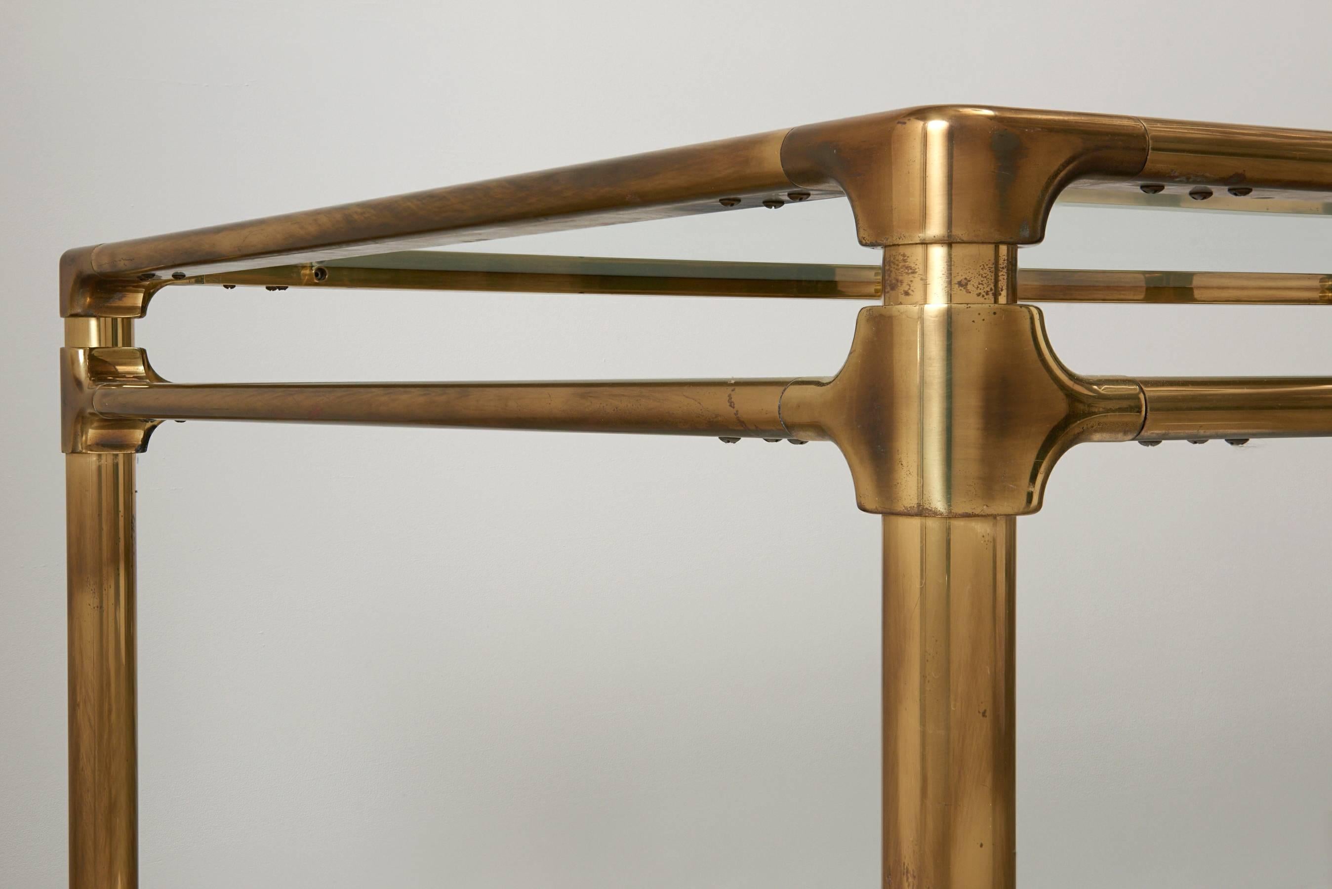 Oversized brass and glass dining table produced by Mastercraft in the early 1970s. Brass frame is lightly patinated with a brushed pattern. Glass has been replaced. 

Table breaks down for shipping.