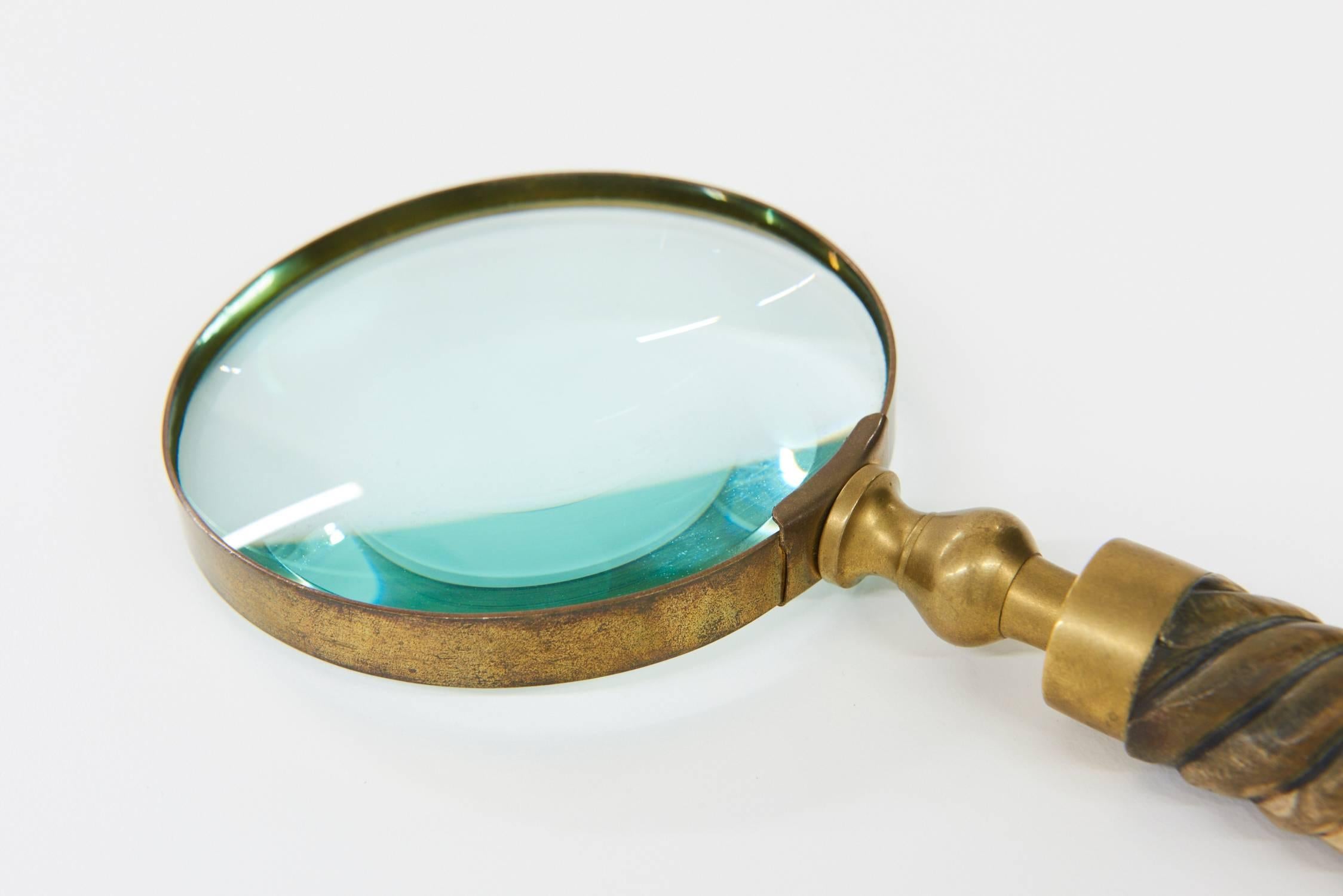 Decorative and useful vintage magnifying glass. The brass fitting has nice patina. Actual glass is in great condition - no cracks or chips. Delicate hand-carved wooden handle has slight curve and nice wear and patina.