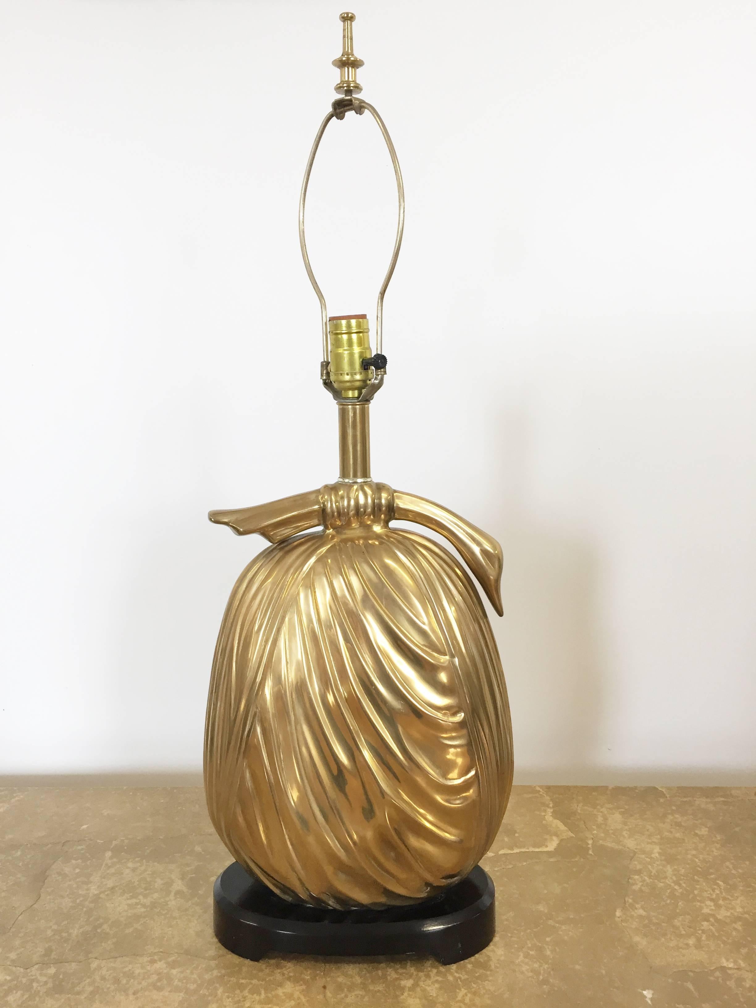 Asian style Midcentury table lamp by Chapman. Weighty brass bundle form sits atop dark wood Asian-style base. Brass with great patina. Unusual form that produces a lovely warm light. 18 in. high to top of body of lamp; 29 1/2 in. high to top of