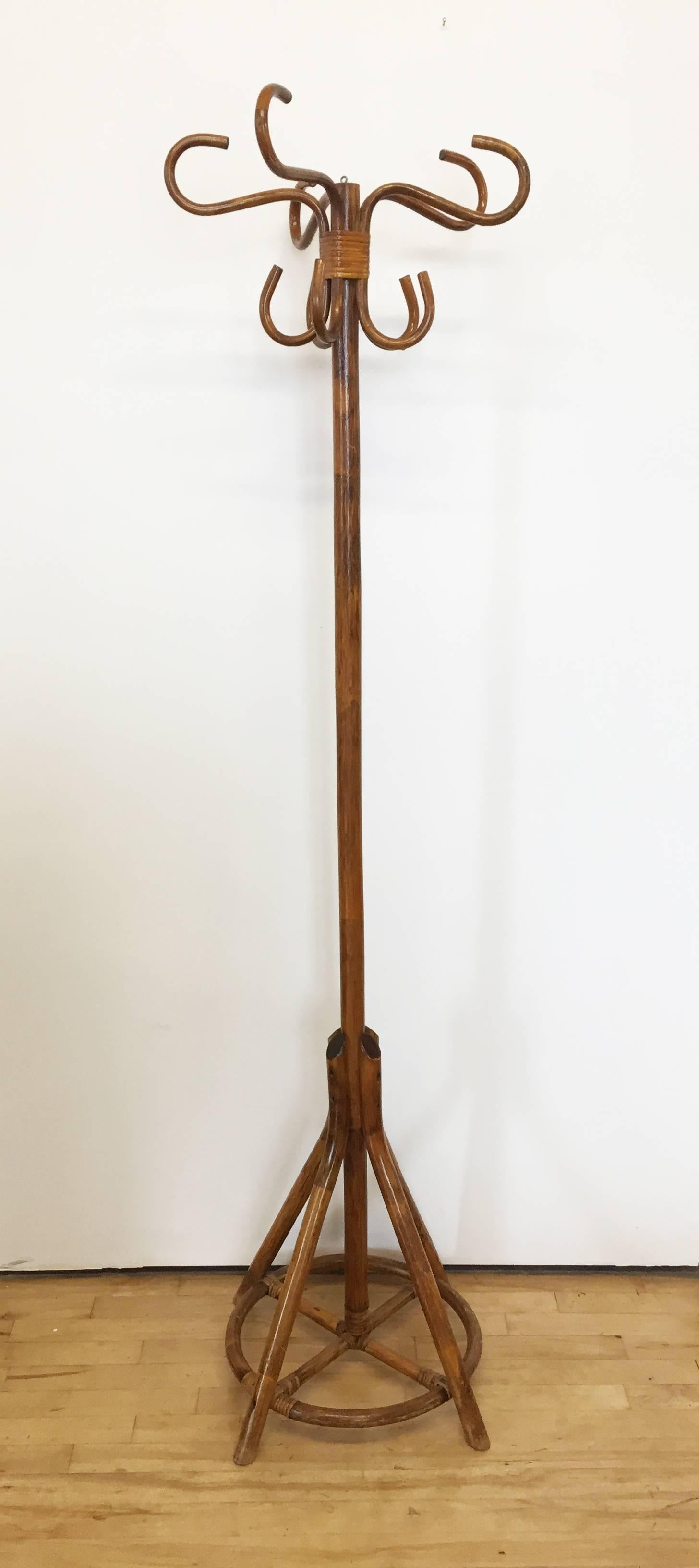 Fun and quirky vintage coat rack or stand made from stained bamboo. Five double hooks serve as coat or hat hooks. Central rod is stabilized at floor with four legs and decorative ring. 