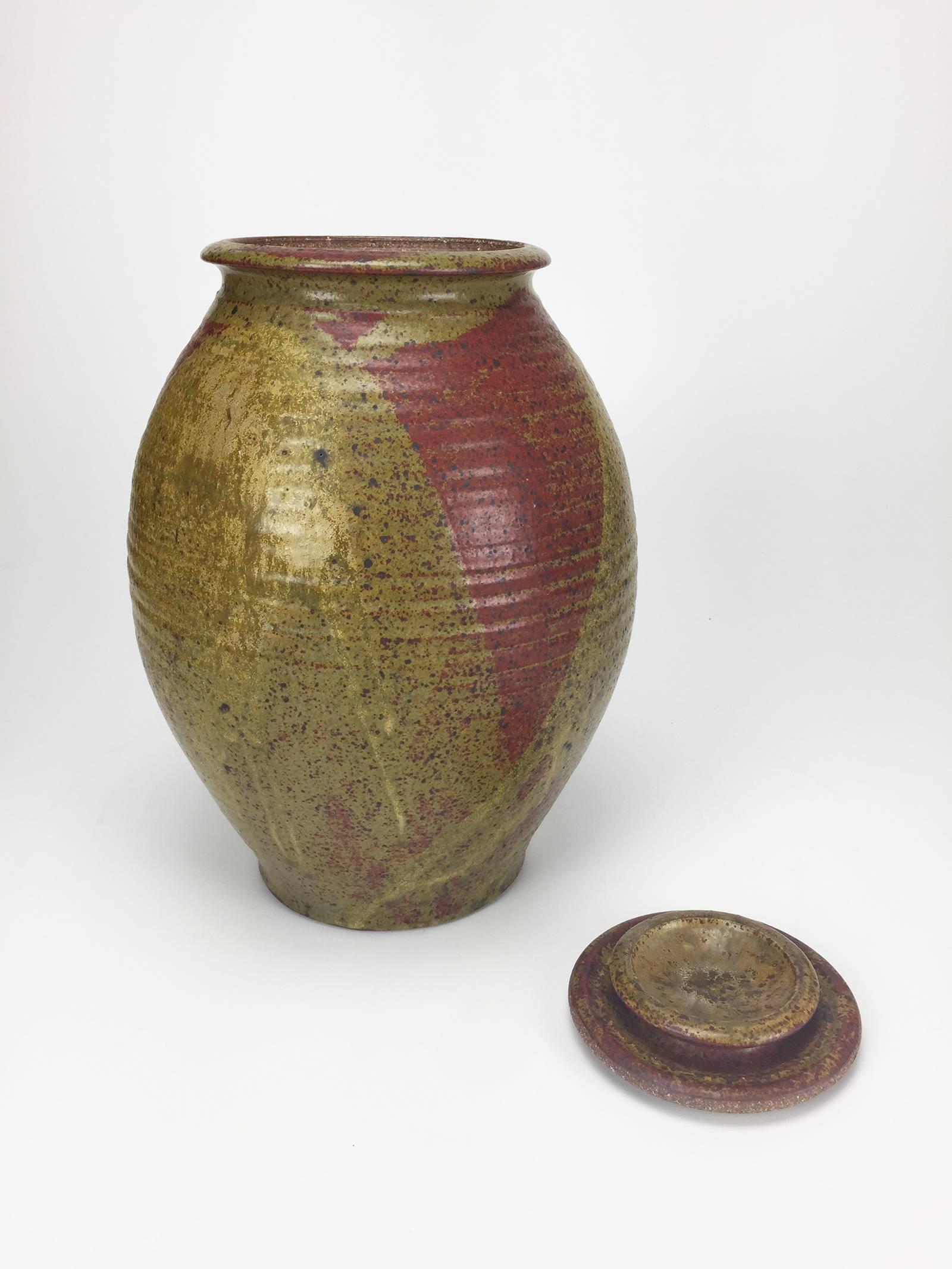 Oversize lidded stoneware jar with red detailing and Robin's Egg blue interior. Produced at the Archie Bray Foundation in Helena, Montana while Ken Ferguson was director; his influence is clearly seen in this piece. Underside stamped with