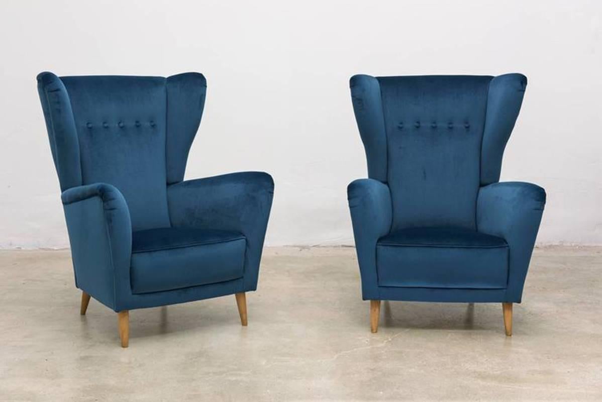 Beautiful pair of Italian midcentury high-backed winged armchairs or club chairs. Upholstered in a blue velvet in excellent condition. Maple legs. 

In the style of Ico and Louisa Parisi, Gio Ponti, Arredamenti ISA.