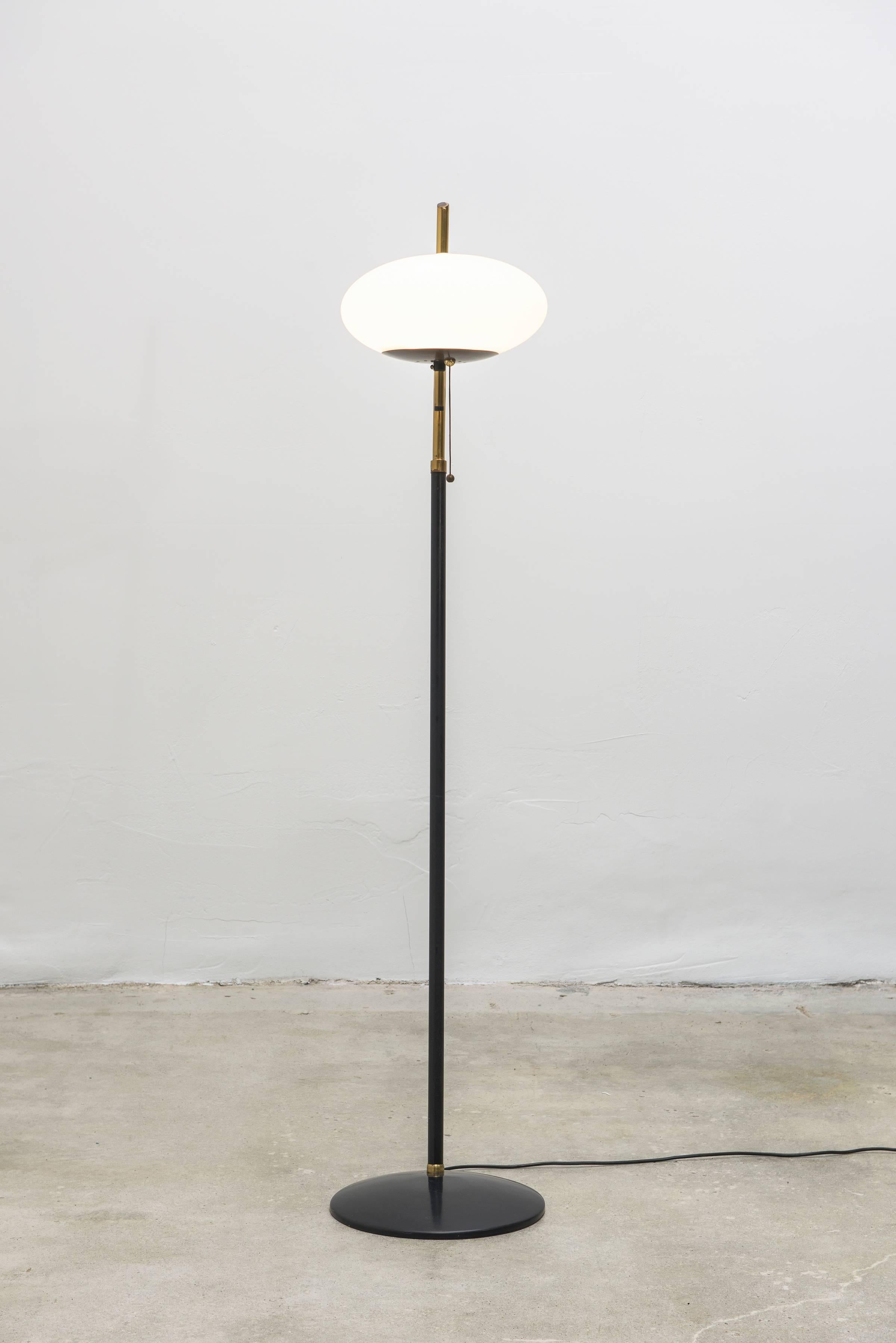 Exquisite vintage mid-century floor lamp, style of Arredoluce, Italy. Standing lamp with classic Italian mid century styling and fine glass globe shade. Body of lamp is black, with brass detailing. Comprised of painted metal, brass and frosted