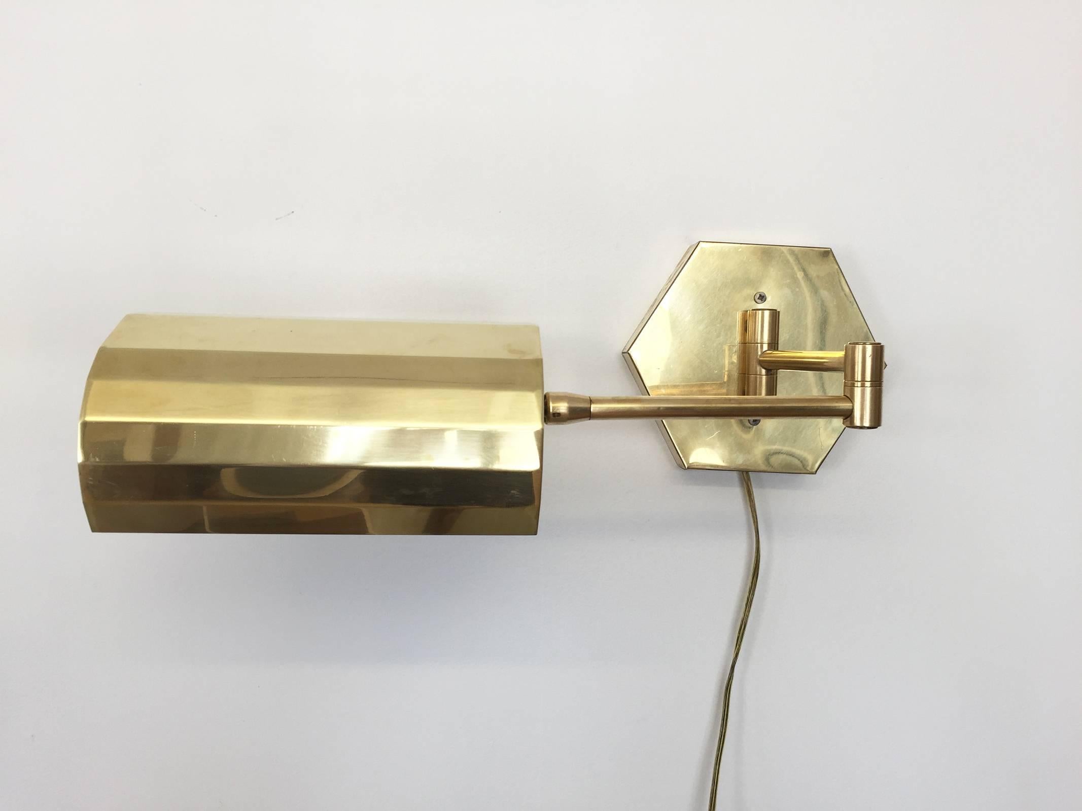 Beautiful vintage articulating swing arm un-lacquered brass wall sconce with octagonal wall plate and faceted brass shade. 

Extends to 21 in. reach.