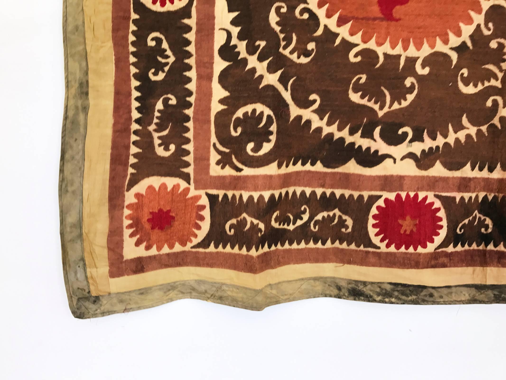 Intricate hand-embroidered needlework Uzbek Suzani with tan background and brown, pink, magenta and green geometric and paisley motifs throughout. Linen and cotton with silk threading. Very large size, can act as a bold wall hanging, bedspread or