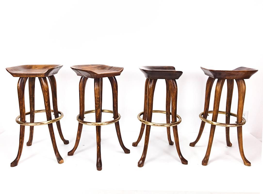 Great set of four counter height barstools with hand-carved seat and legs and brass-plated circular foot band. Underside branded with 