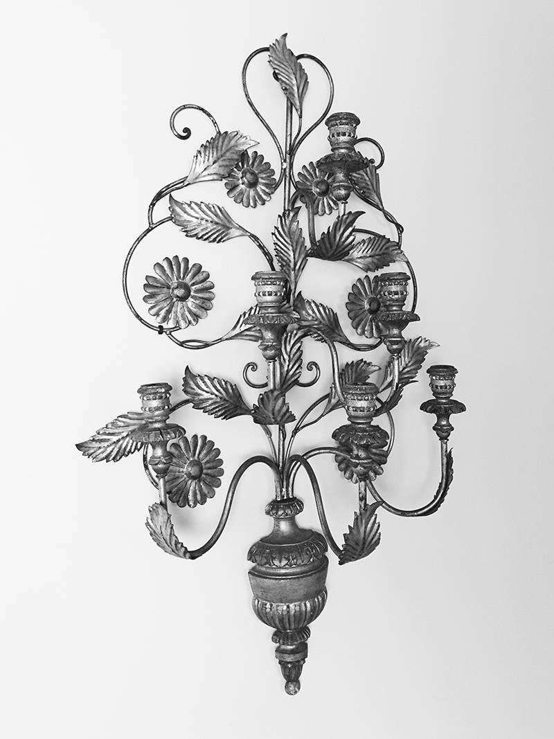 Very large six-arm Italian wall sconce. Body is comprised of silvered metal in foliate form and carved wood finial element and candleholders. Silvered paint throughout with losses and chipping, appropriate to age. Metal tag with 