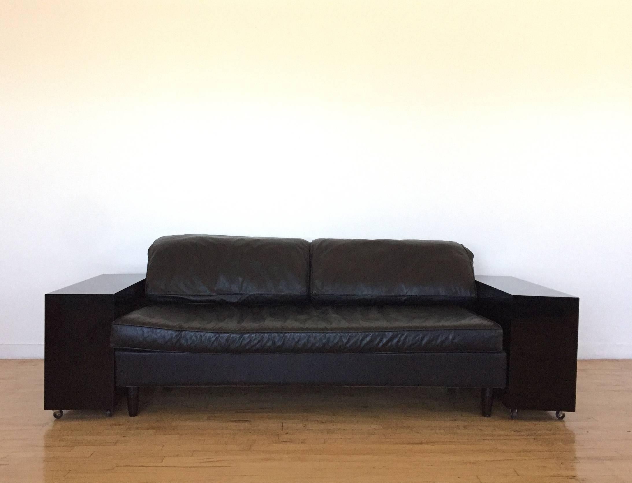 Beautiful "Lota" sofa, designed by Eileen Gray in 1924, manufactured in the 1980s. The sofa is comprised of two black lacquer armrests (on casters) with soft leather cushions that rest over the top and armrests. 

  