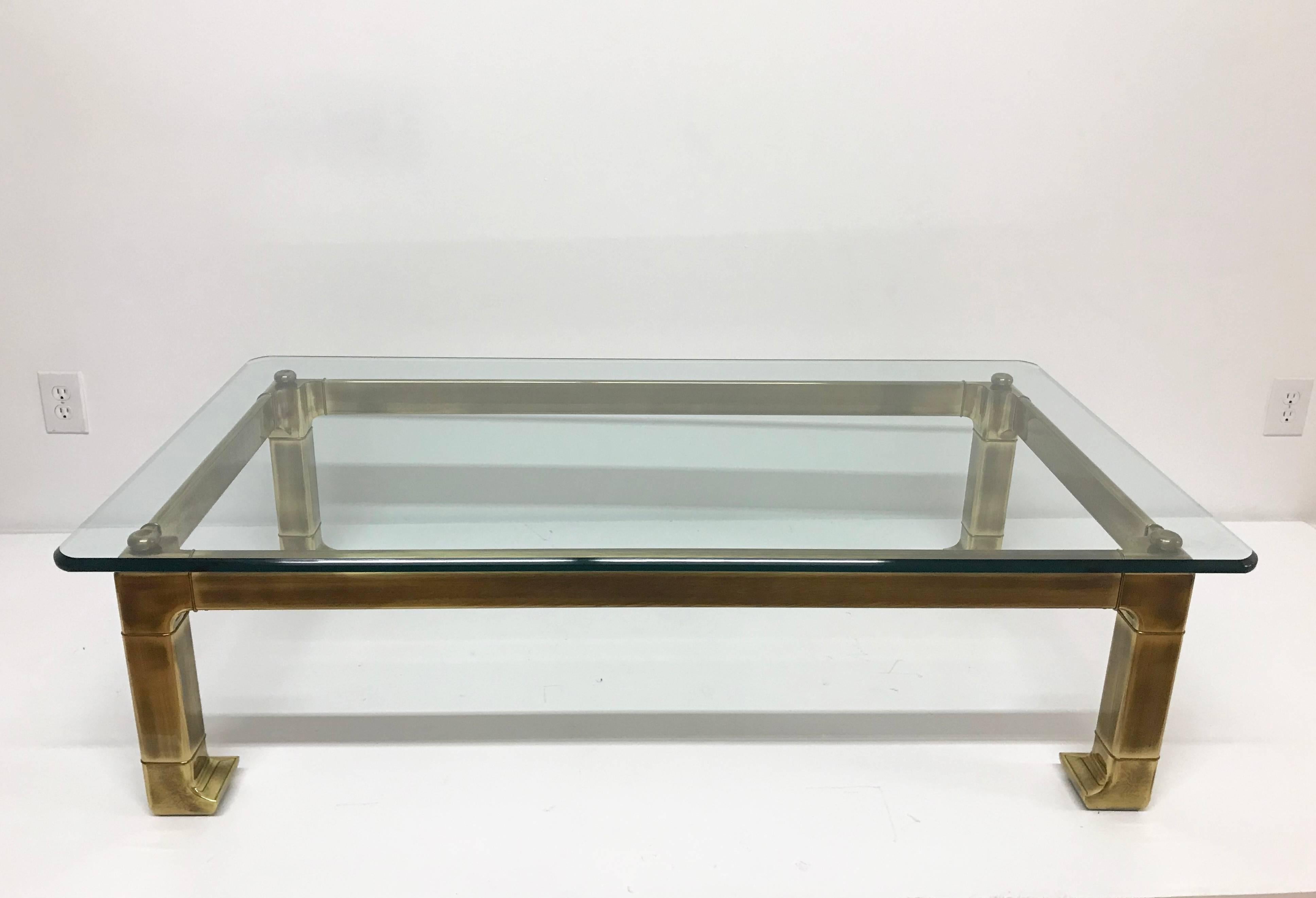 Incredible lacquered brass coffee table with Asian styling and original double thick 3/4 in. glass. Beautiful patina. Both glass and frame in excellent original condition. Hollywood Regency style.