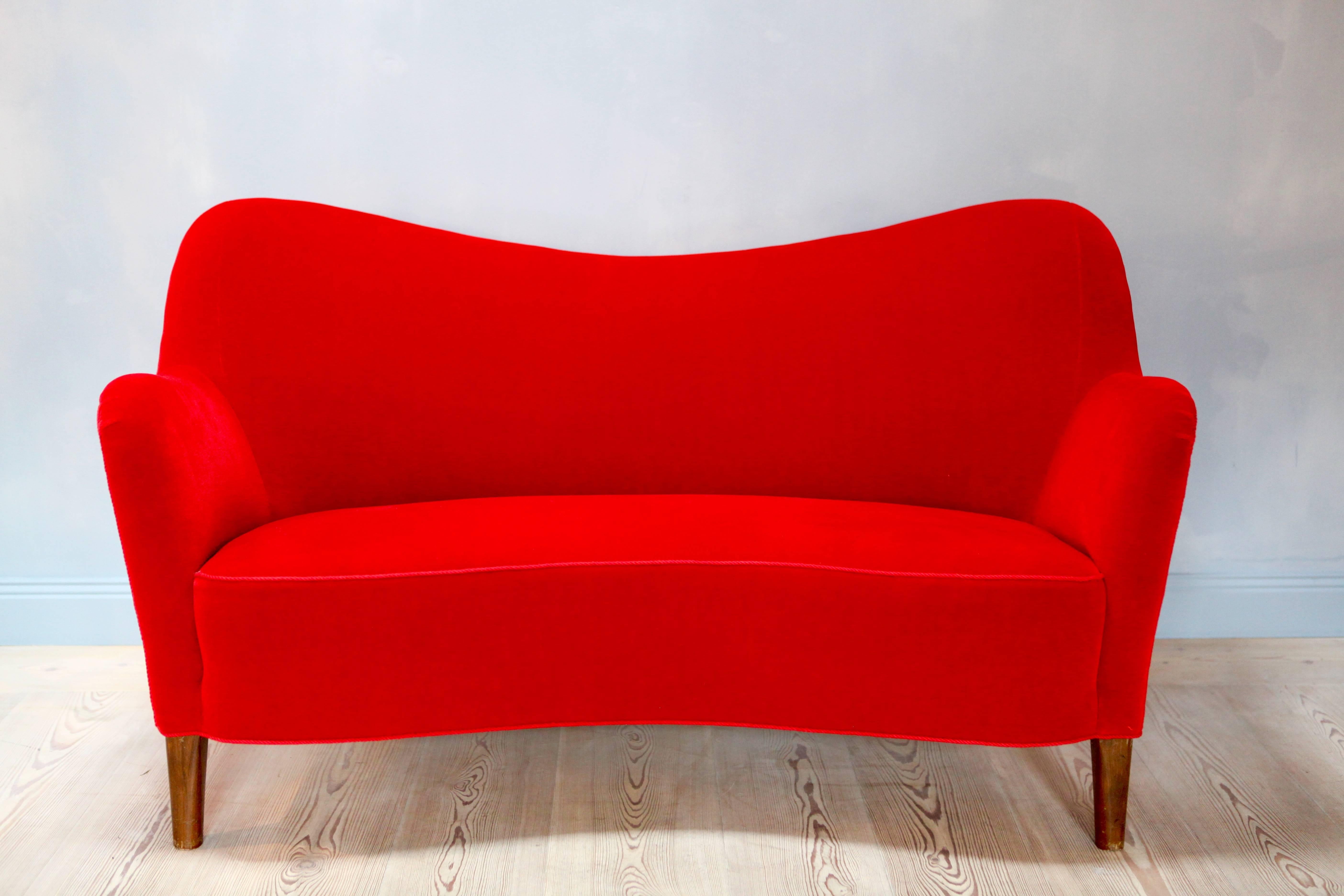A elegant freestanding curved two-seat sofa by Nana Ditzel (1923-2005).
Patinated beech legs.
New upholstered in Raf Simons lipstick red mohair.