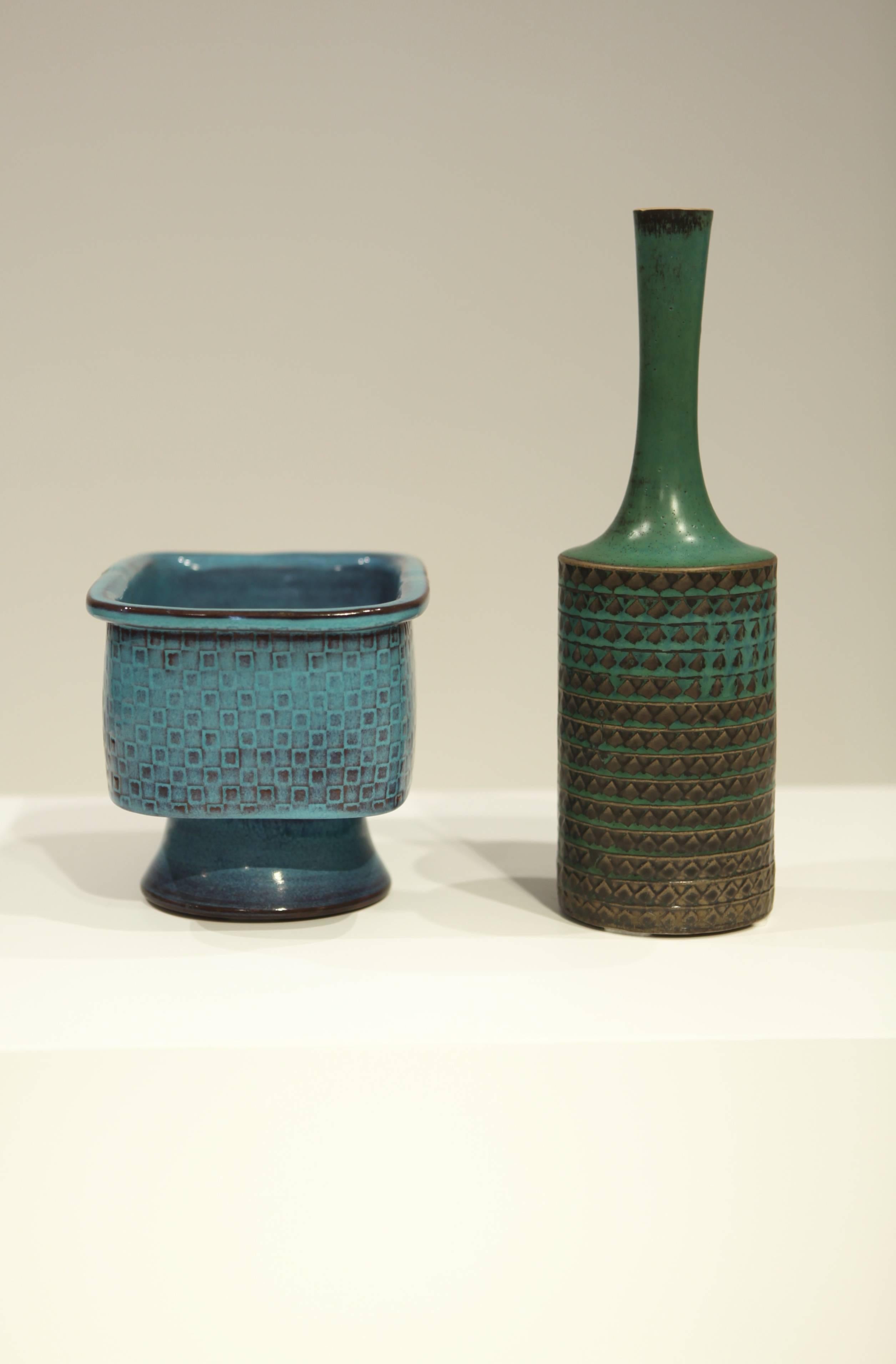The Turquoise glazed is Gustavsberg Studio 1967, with a square decor.
Signed G, Studiohand Stig L. / 13.5cm high, 20cm wide and 14cm deep.

The vase in the green glaze is Gustavsberg Studio, 1965.
Signed G, Studiohand Stig L. / 29.5cm high, 9cm