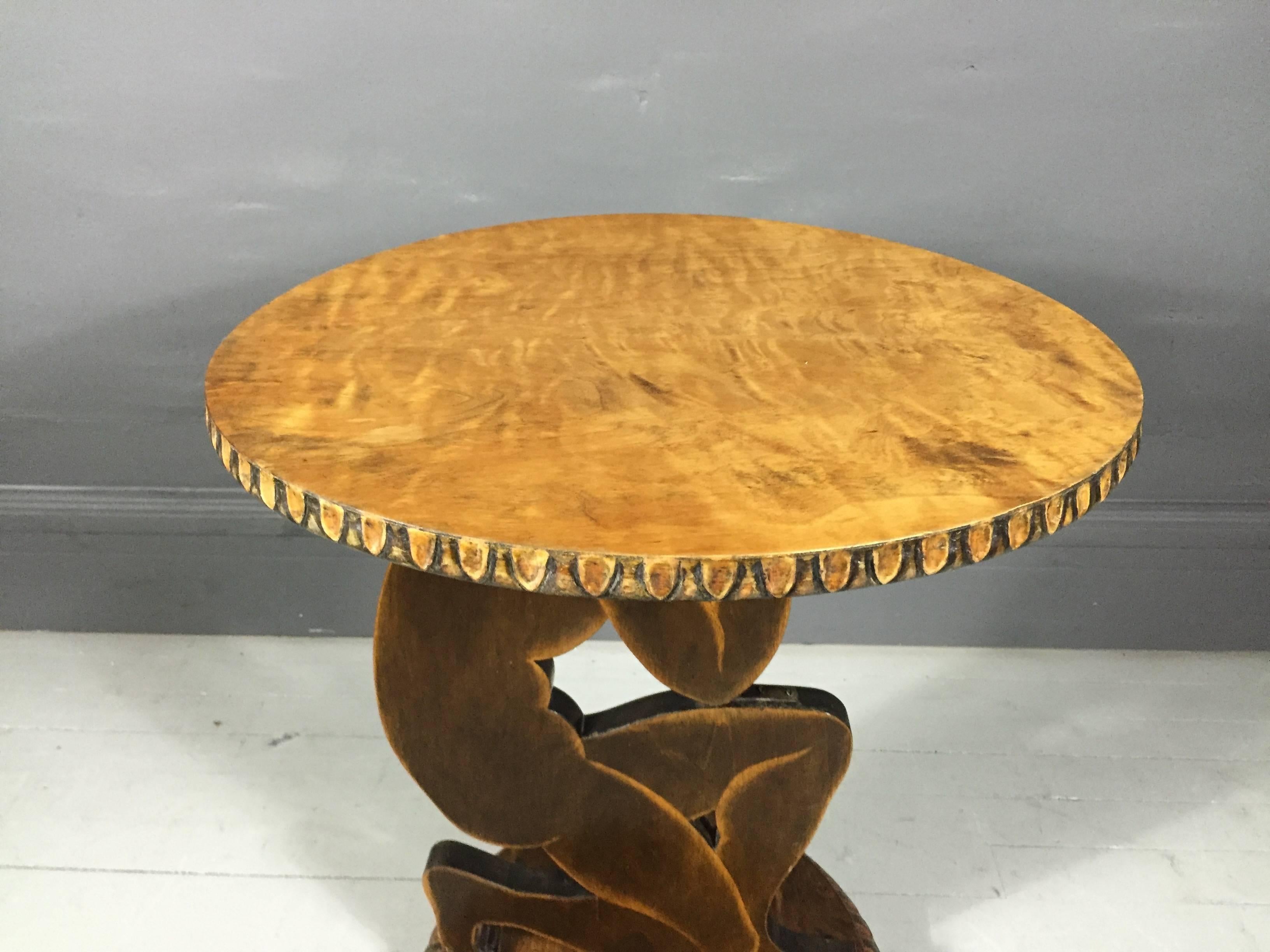 A spectacular and rare side table in birch wood carved in a female figure holding a light stained and decorated round disk or top, France, circa 1920s.

Wonderful vintage condition.  Slight bow to edge of table top.