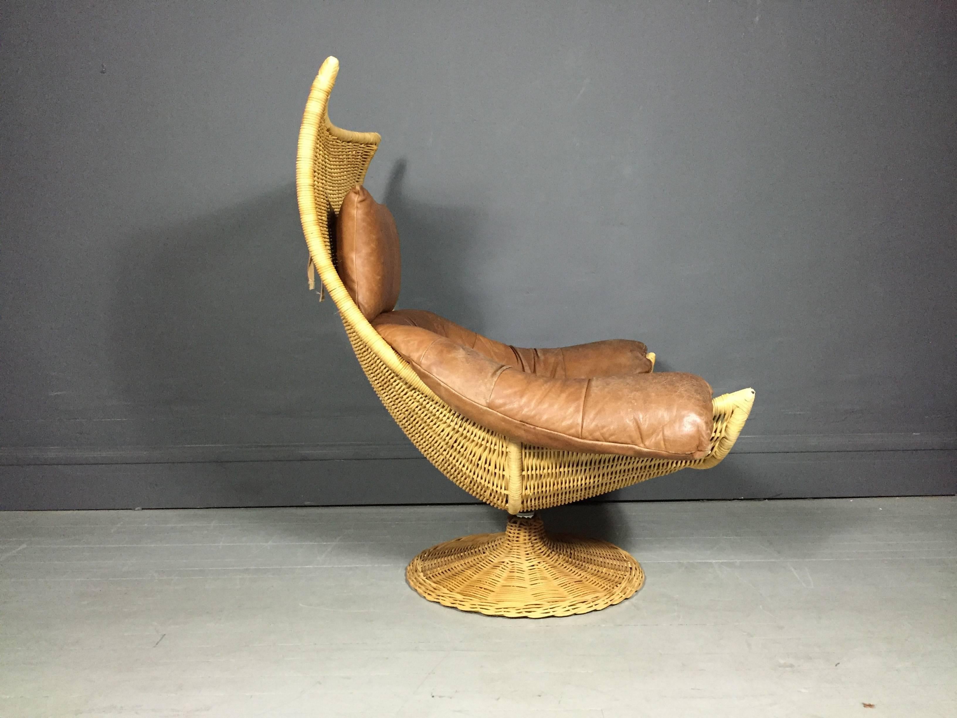 Incredible vintage condition large-scale swivel lounge chair in perfect rattan and original brown leather with neck pillow on swivel steel and rattan base. Designed by Gerard Van Den Berg for Montis, Netherlands, circa 1970.