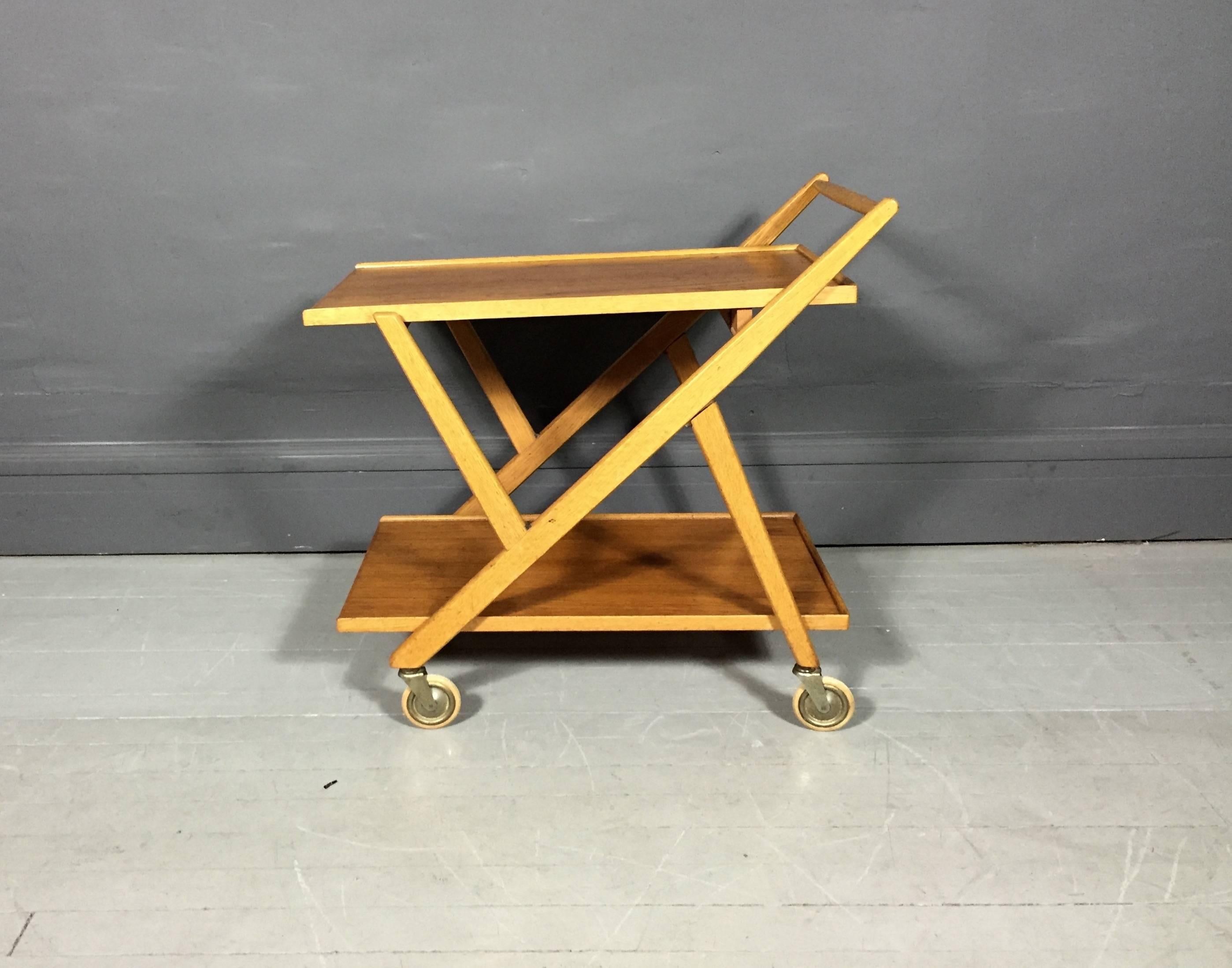 Scandinavian modern at its best. Oak frame two-tier trolley barcart that collapses to flat position with rubber and brass wheels by Fröseke AB, Nybrofabriken, Sweden, 1950s.