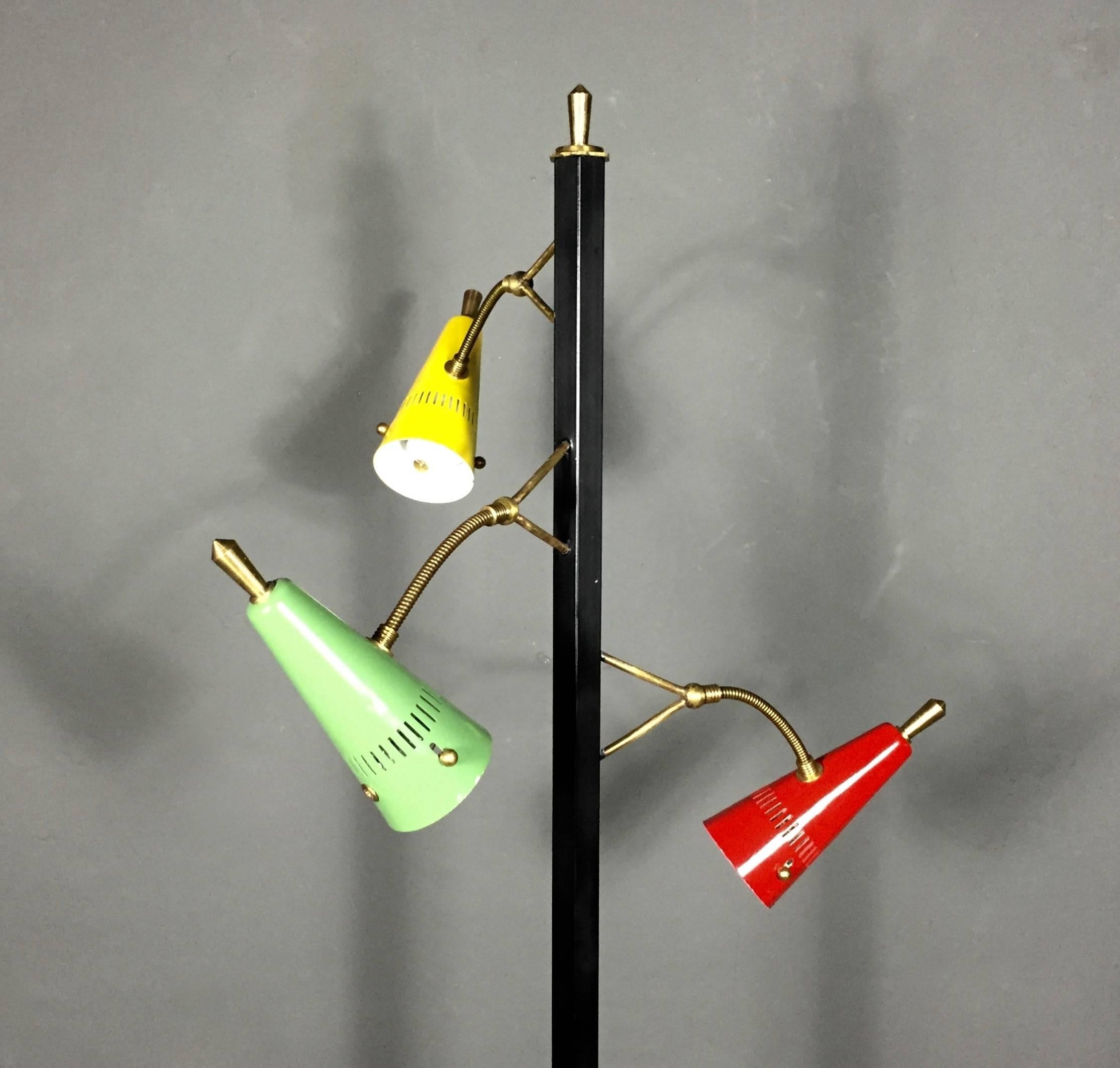 An unusual floor lamp with Classic enameled and perforated metal (red, yellow and lime green) with black painted stand on atypical triangular-shaped marble base. All three lamps have adjustable heads and supported by dual brass arms. Floor-foot