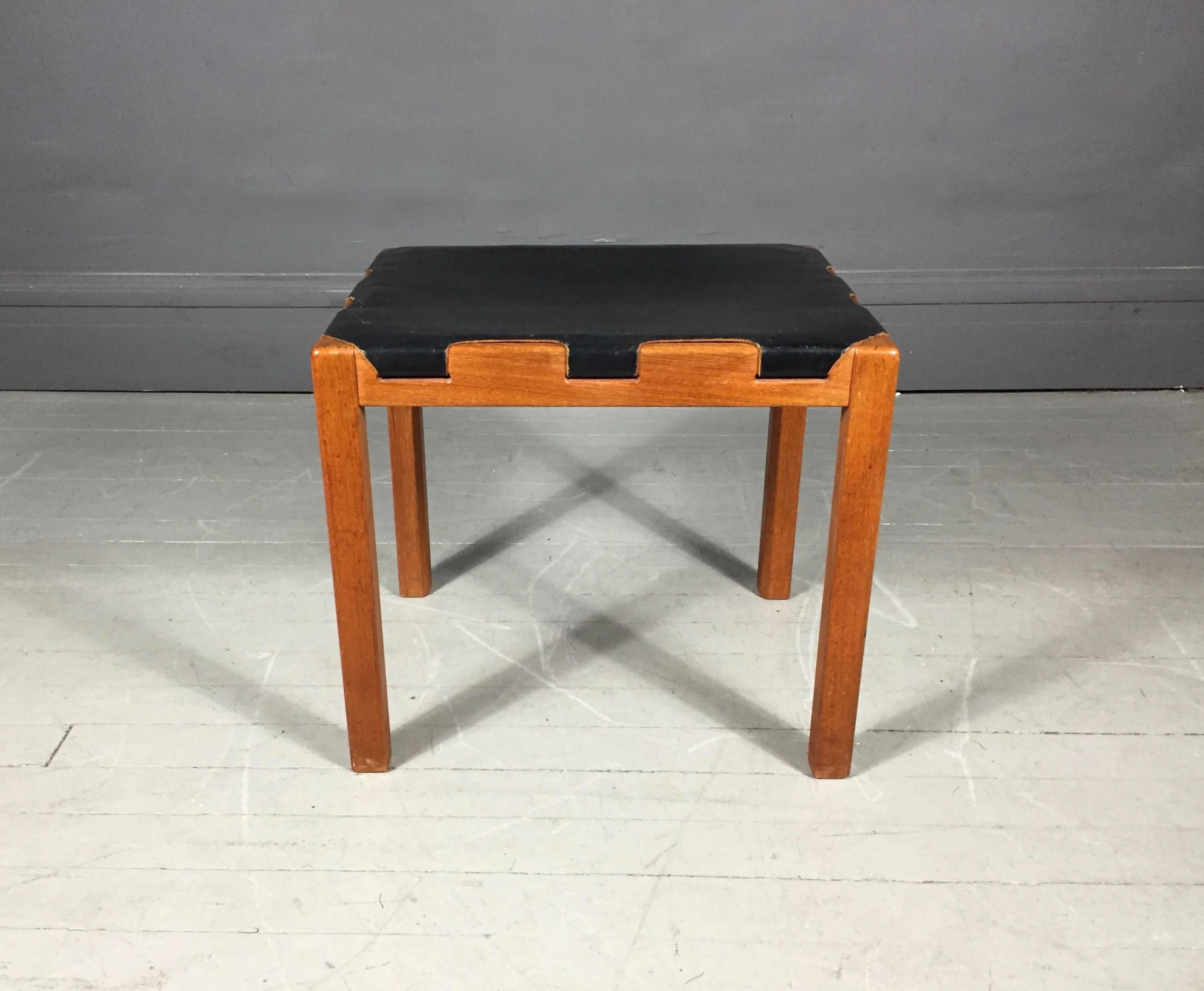 Wonderful condition Scandinavian small side stool, simple and gorgeous. Solid teak frame covered with black leather strapped through four sides, additional canvas webbing underneath, by Glasmäster in Markaryd, Sweden, 1960s.