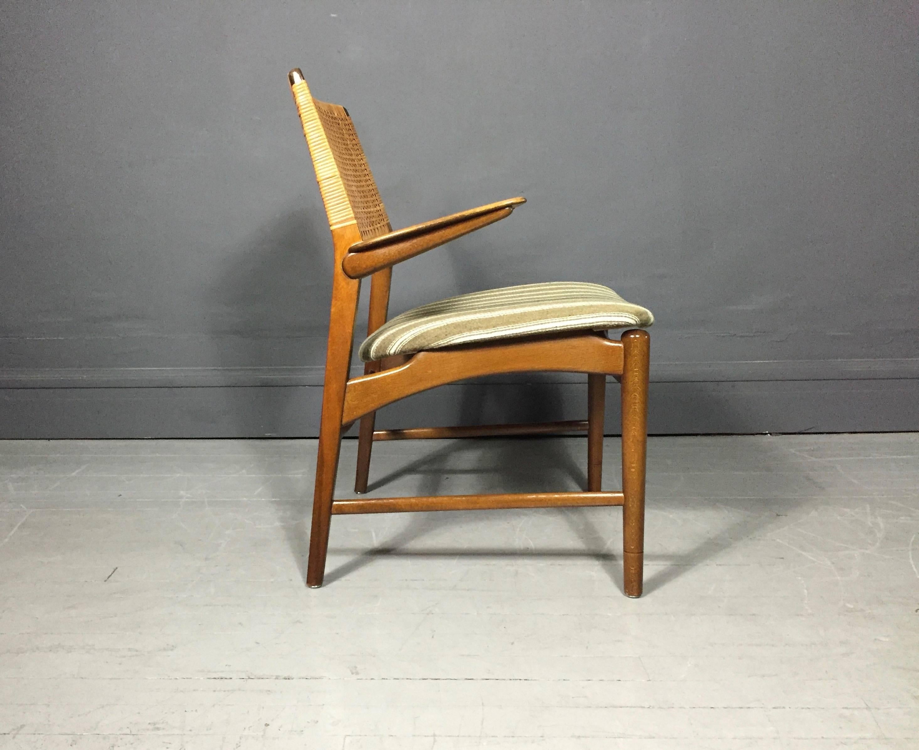 A sophisticated and chic armchair with solid beech frame, cane back, seat upholstered in striped wool fabric, designed by E. Knudsen for Jensen & Lykkegaard, circa 1956, Denmark. Excellent condition.