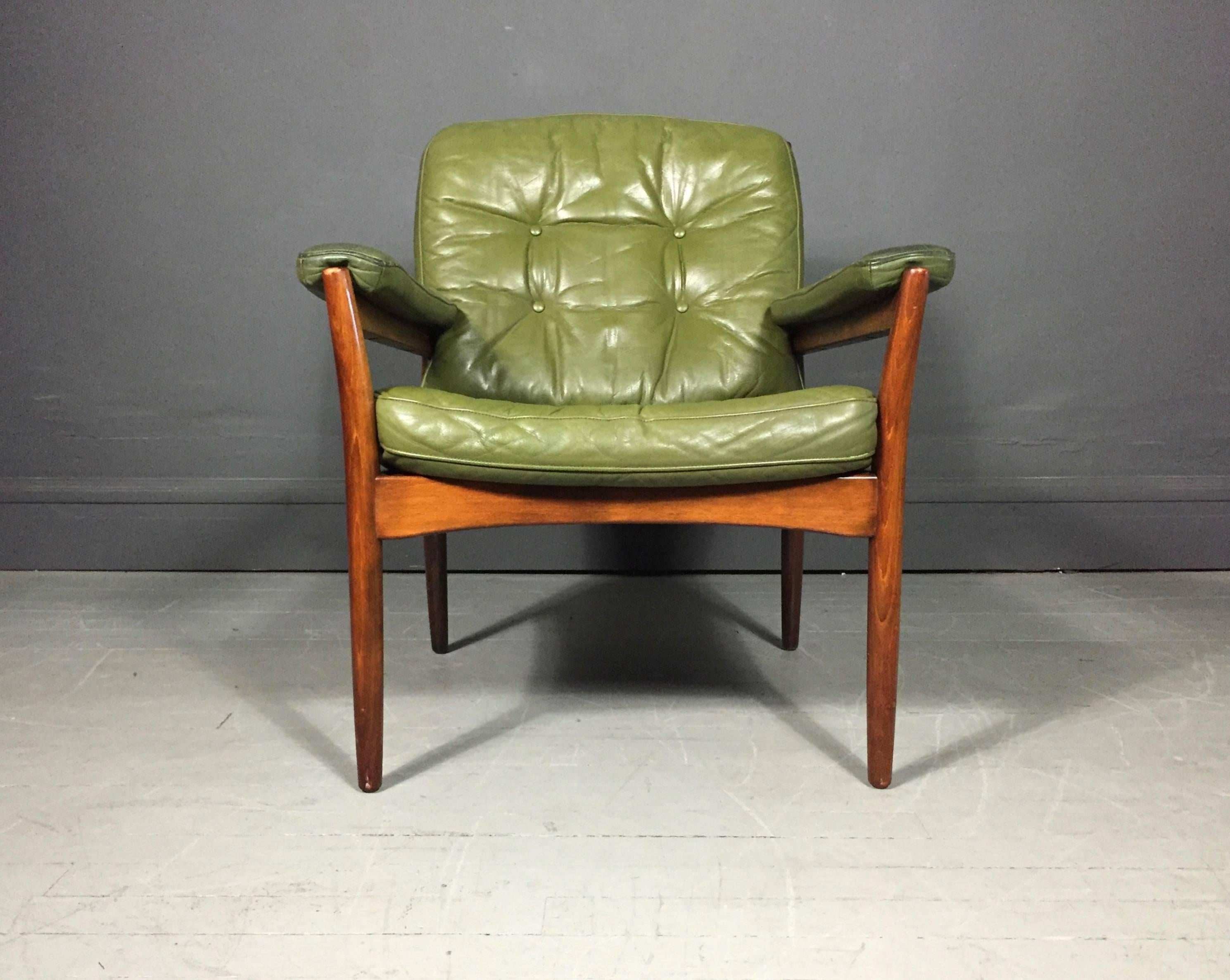 A classic Swedish design with generous proportions not typical of Scandinavian furniture of the period. Luscious and soft button tufted green leather seat, back and arms on a solid teak frame. Designed by Gate Möbler of Sweden, made between