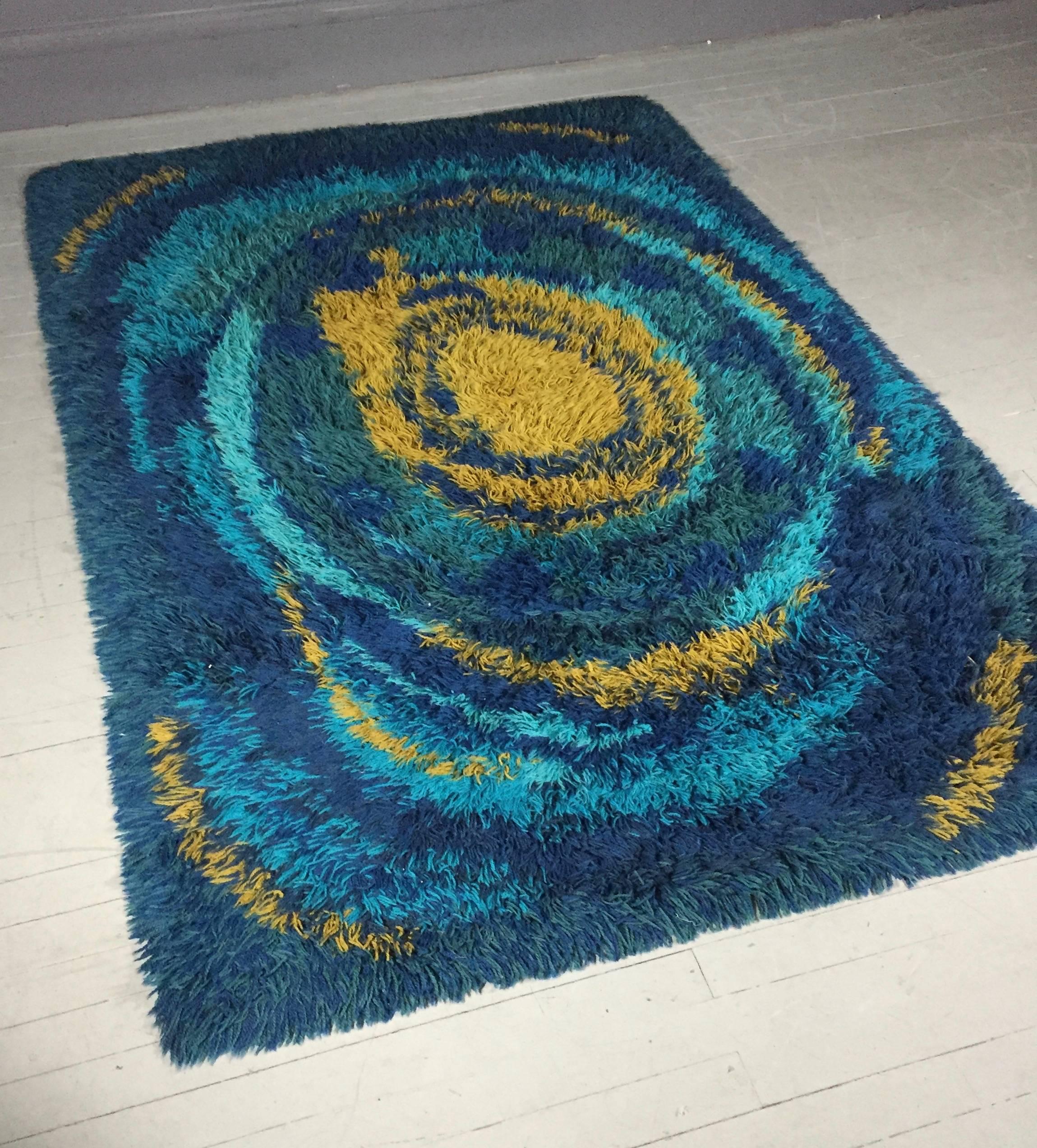 A very vibrant Rya with blues and mustard yellow coloration and swirl design. Measures: 79